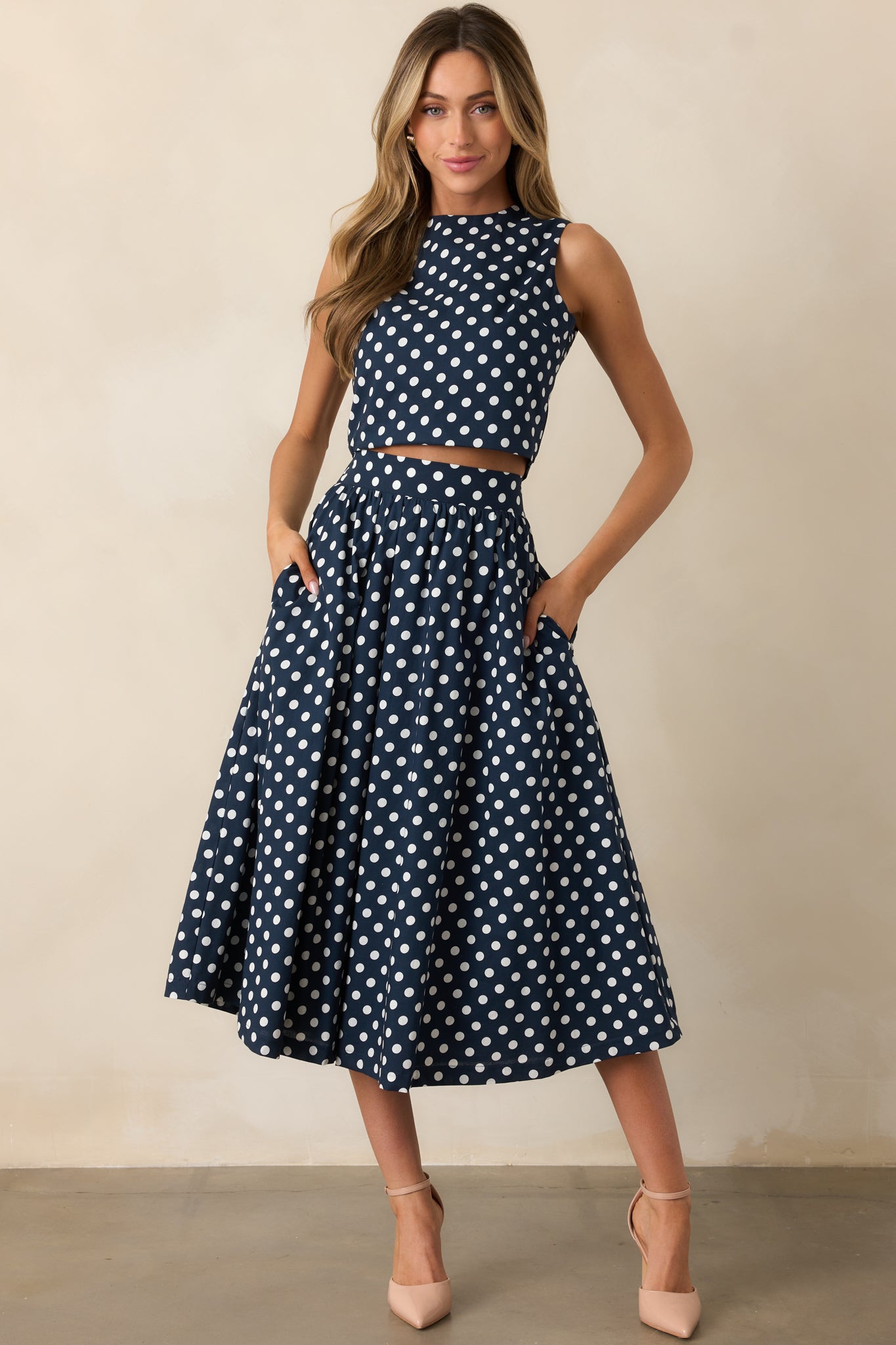 Midi skirt with navy and white polka dot print, styled with a flowing A-line silhouette and functional pockets.