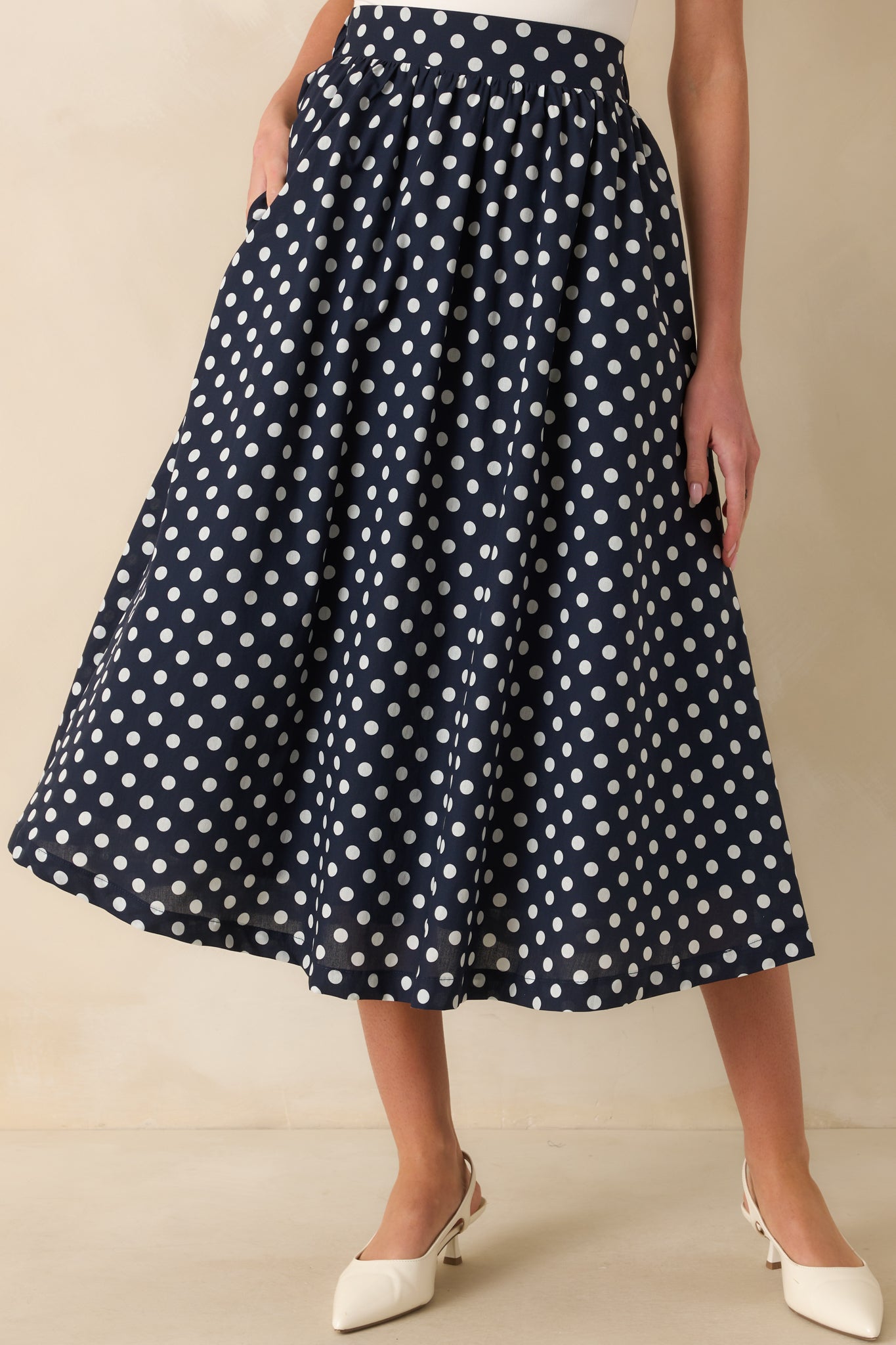 Detail view of polka dot skirt’s waistband and gathered pleats.
