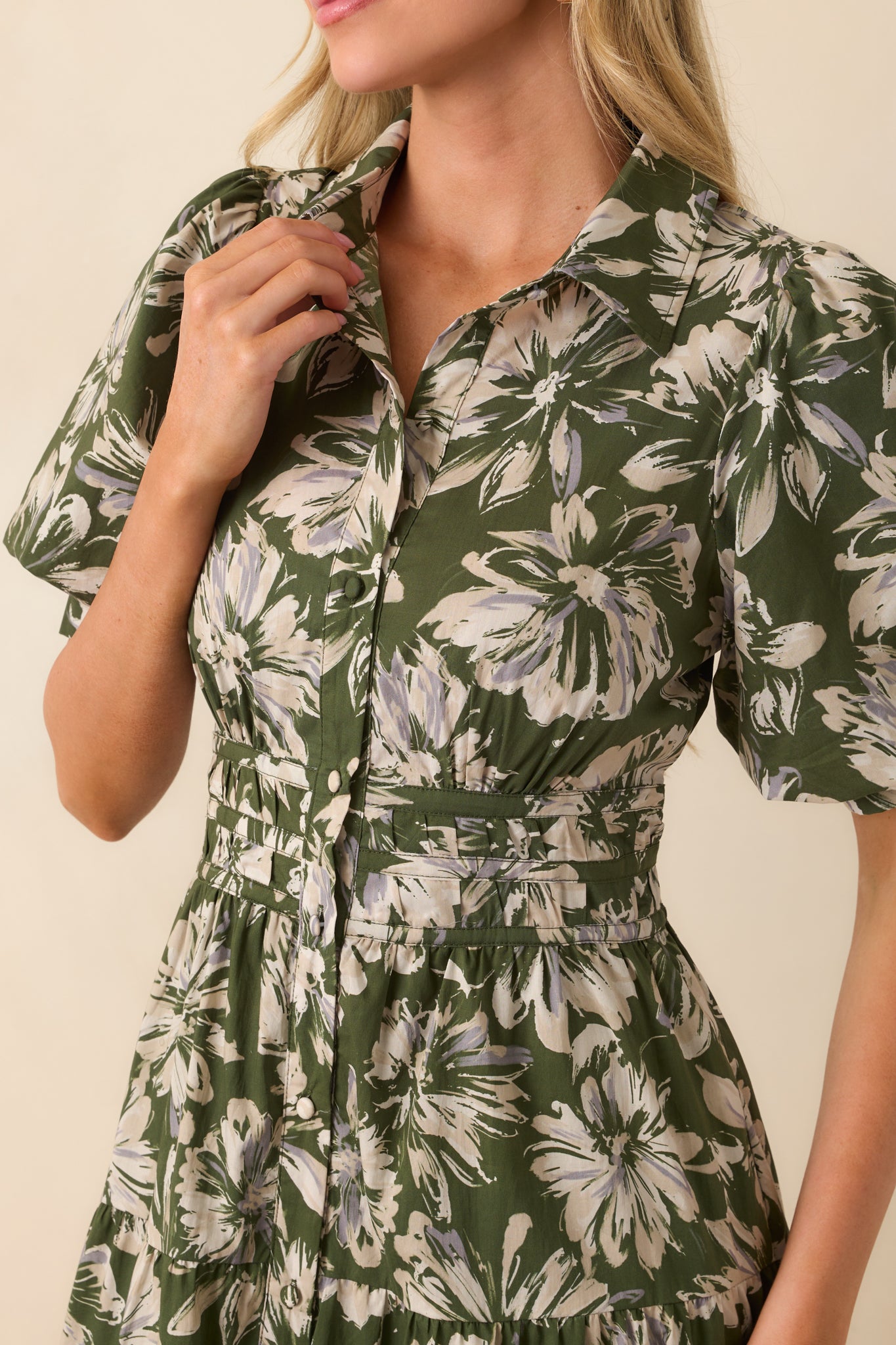 Close-up of the front waist panel and button placket, showing the ruched detailing, floral print, and textured fabric.