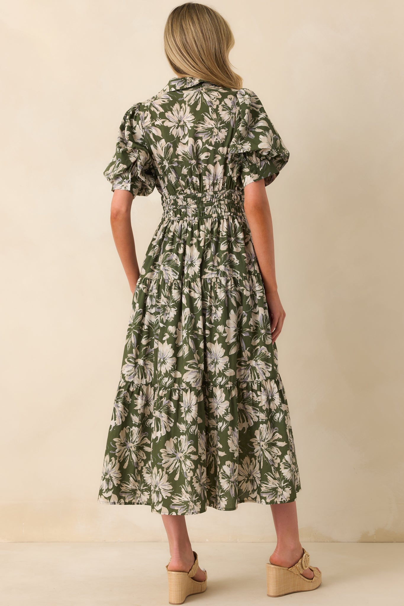 A view from behind of the maxi dress showing the smocked back waist panel, short puff sleeves, and full tiered skirt.