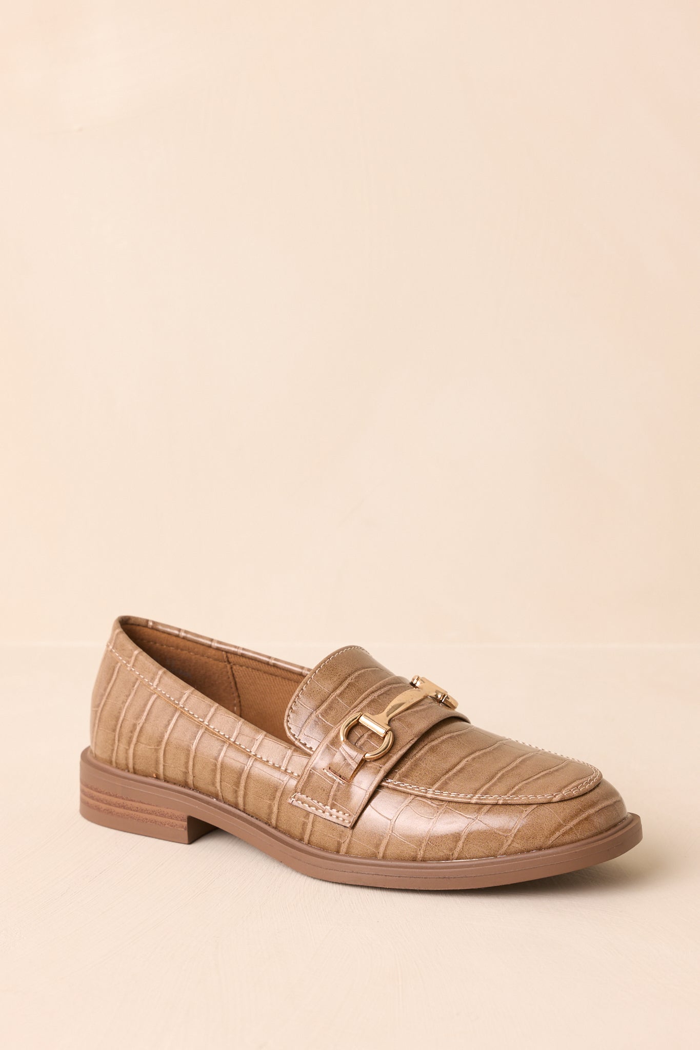 Three-quarter front angle of the loafers showing both the vamp detail and embossed leather.