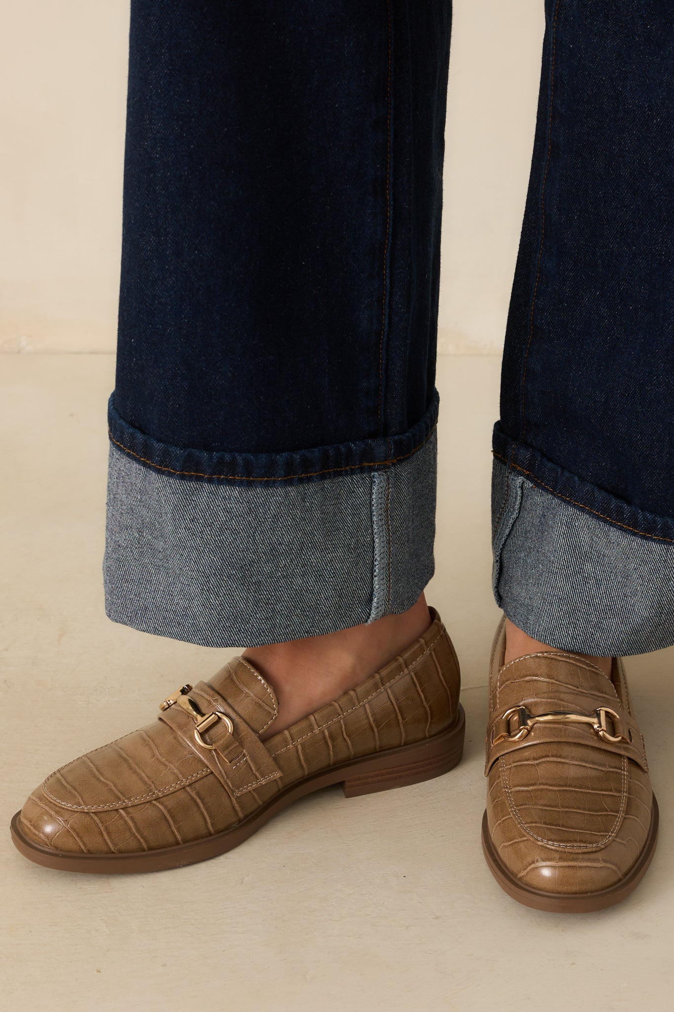 Cropped front view of olive taupe loafers highlighting the structured almond toe and croc-embossed faux leather upper.