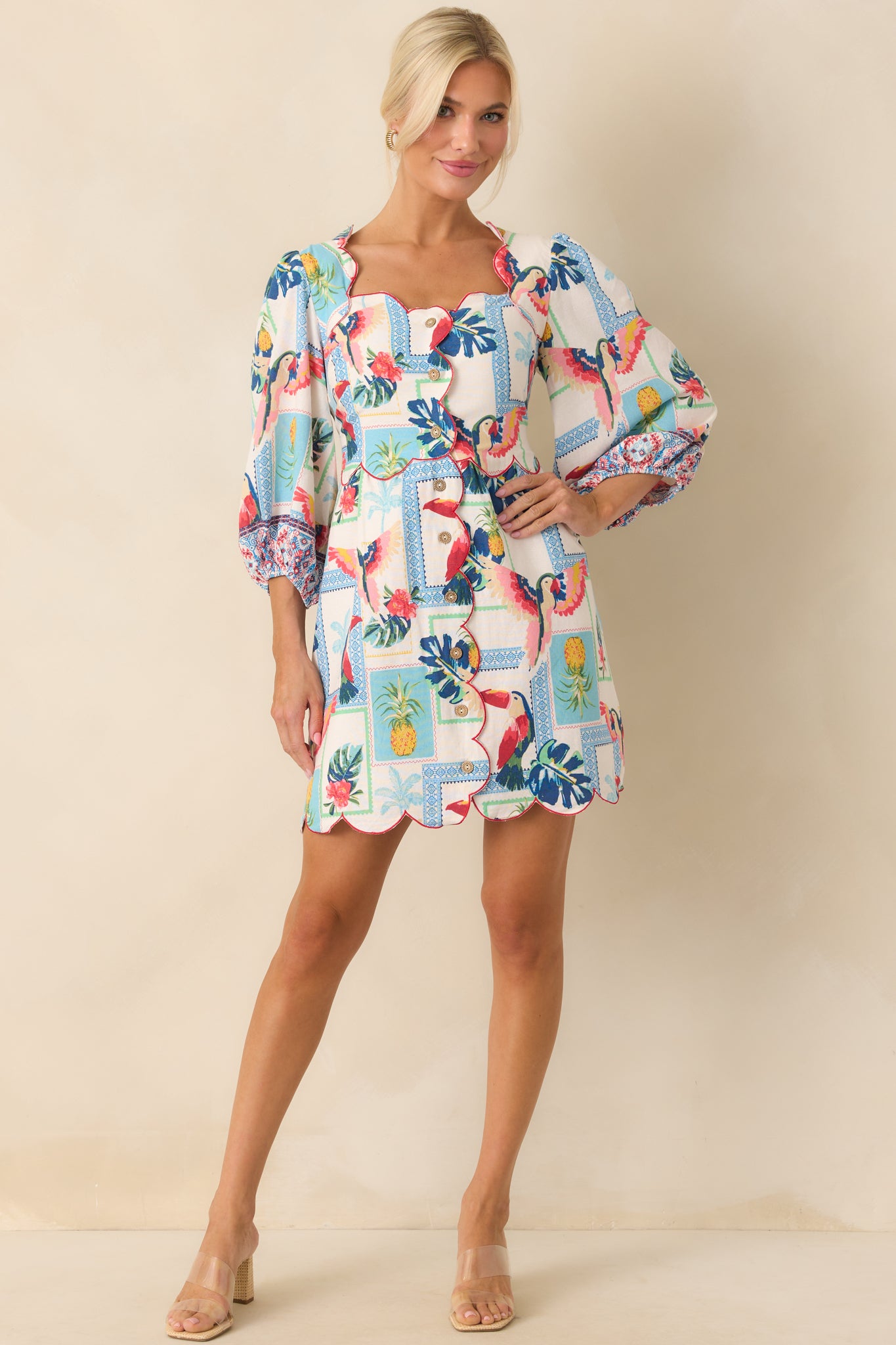 Full body front view of the mini dress featuring a scalloped square neckline and red embroidered scallop trim on an ivory base.