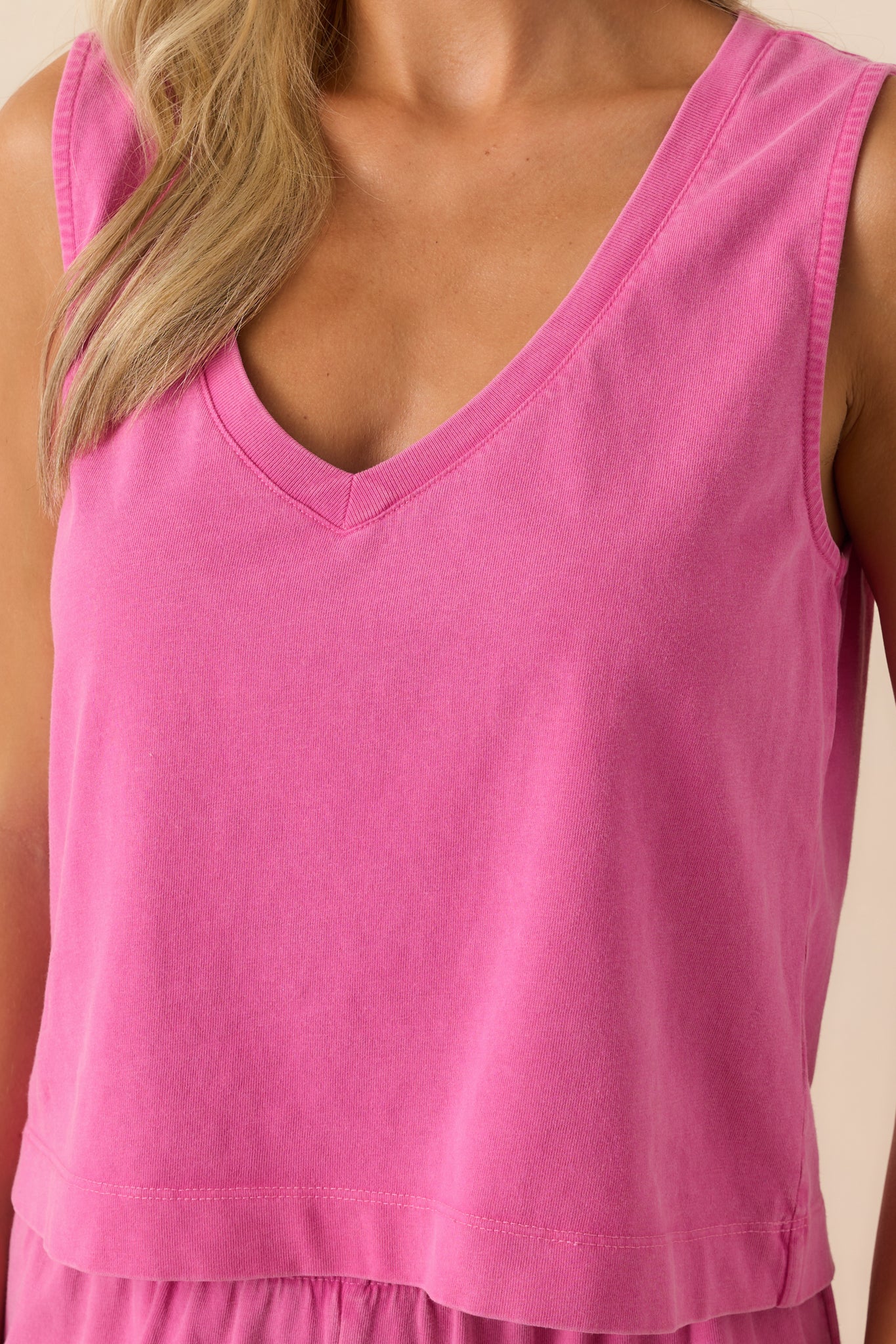 Close-up of the fabric and neckline, showcasing the texture of the cotton and neat stitching along the v-neck.