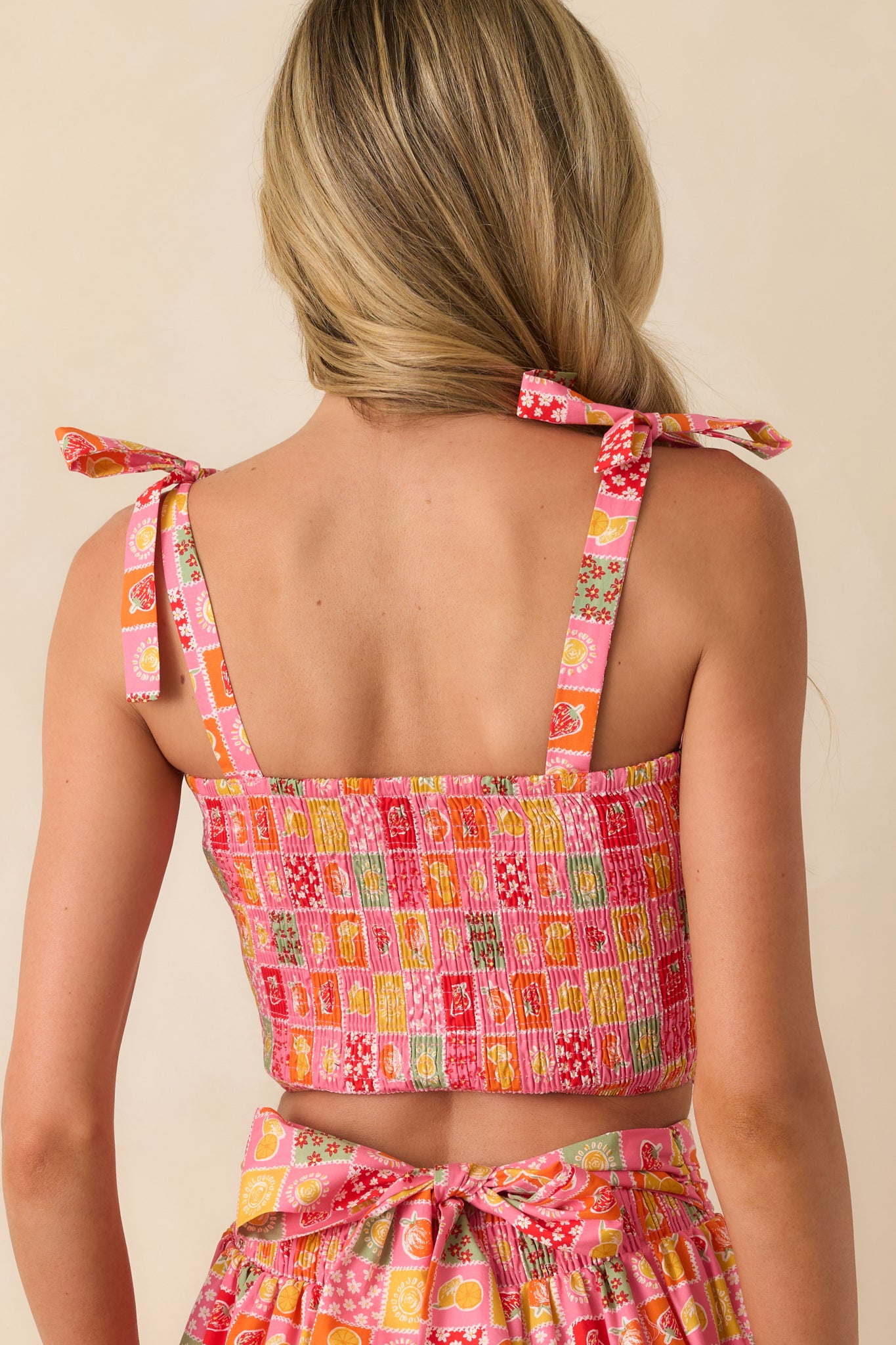 A view from behind showing the continuation of the smocked design and bow-tied straps across the upper back.