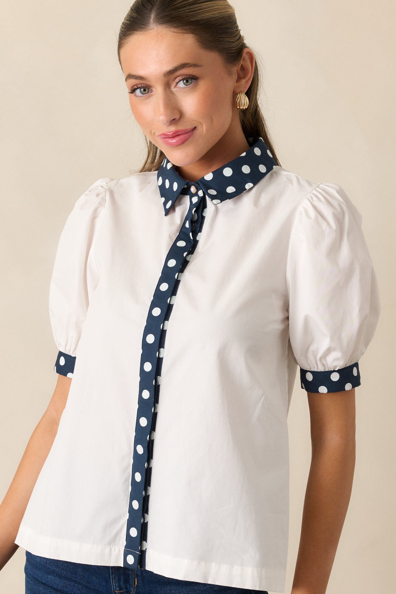 Cropped view highlighting the front placket’s navy polka dot pattern and button details.