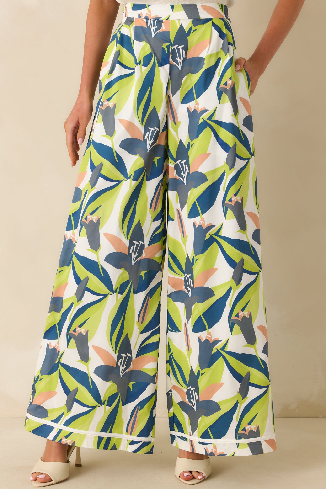 Cropped view of high-rise floral print pants showing elastic back waist insert and functional hip pocket detail.