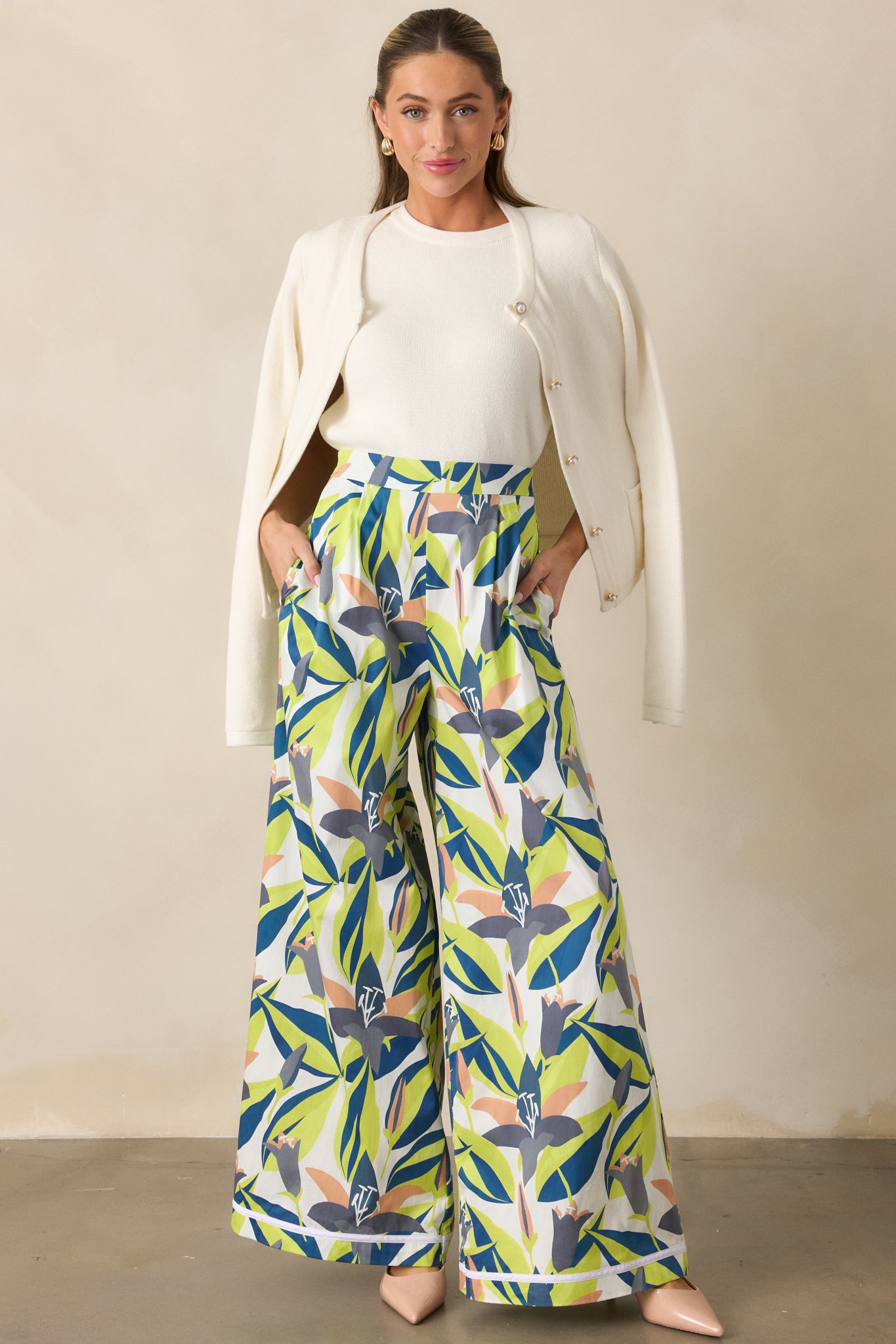 Front view of wide-leg pants featuring hidden side zipper, faux back slit pockets, and vibrant floral print.