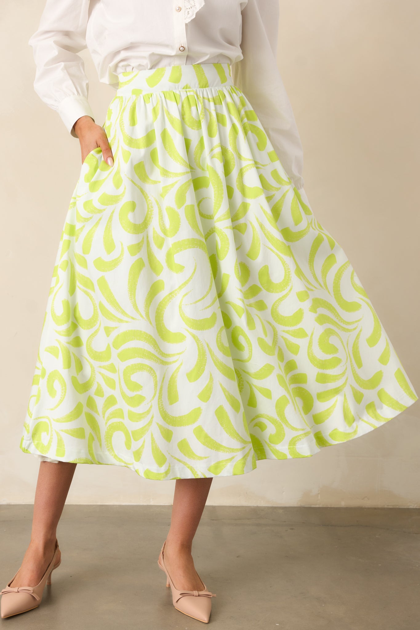 Cropped view highlighting printed fabric and pocket detail on midi skirt.