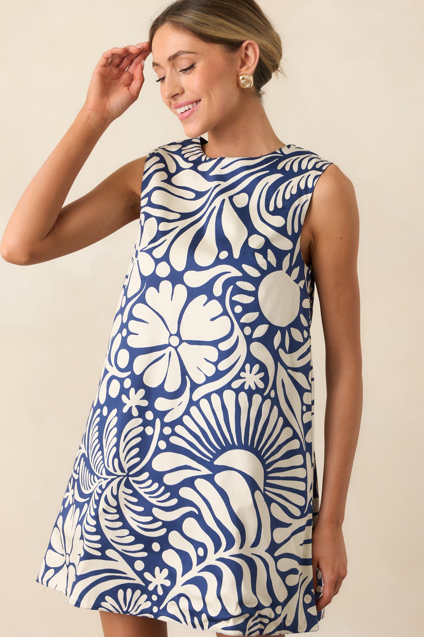 Cropped view of sleeveless mini dress showing round neckline and floral print detail.