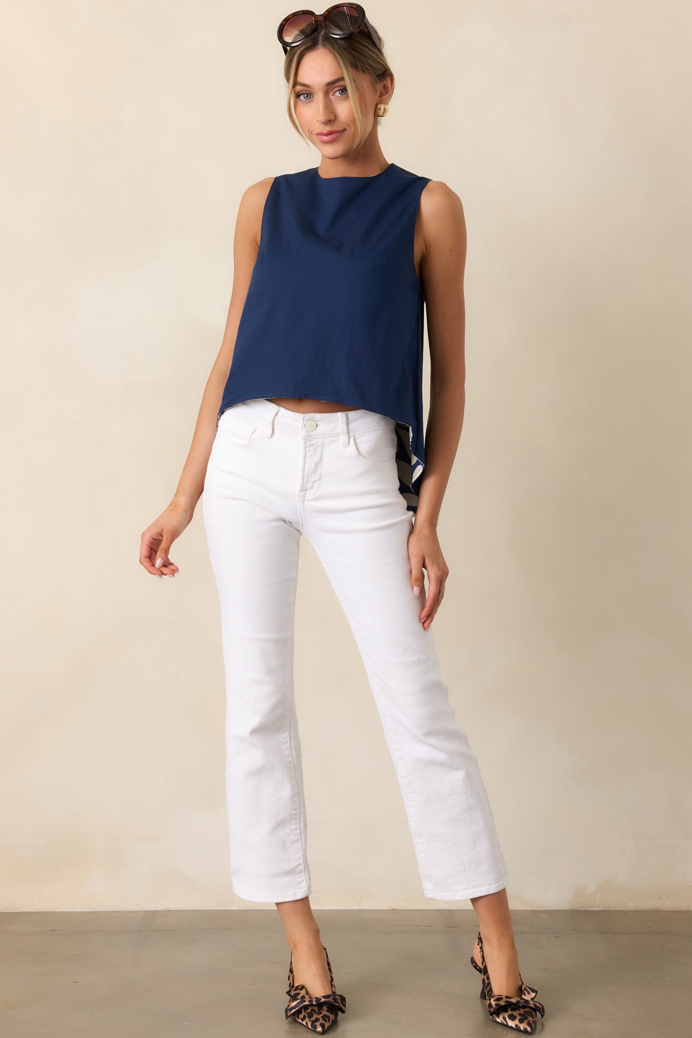 Full front-facing view of navy top highlighting scoop bottom hem and asymmetrical two-tone design.