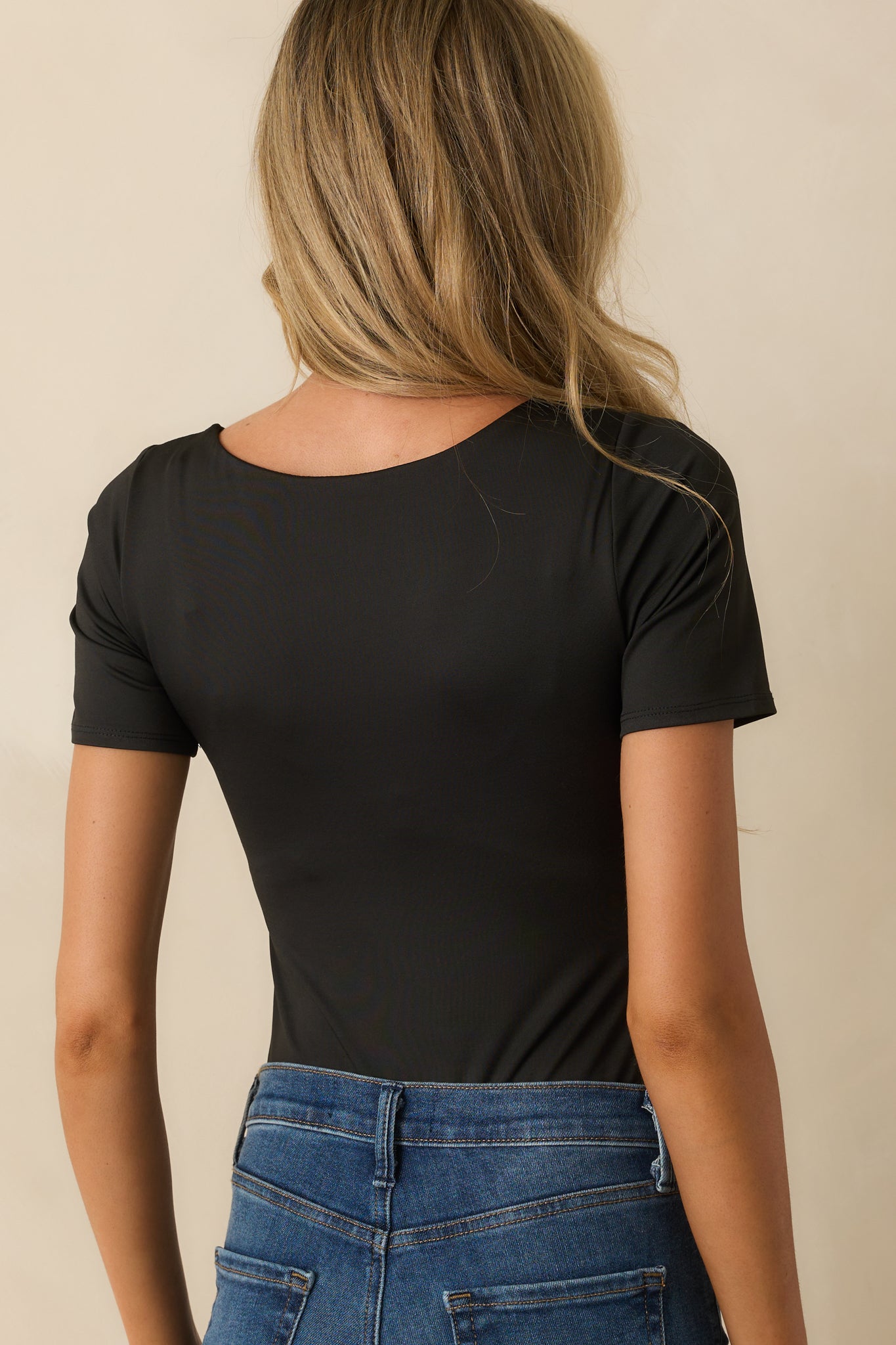 Rear view of the black bodysuit with a smooth fitted finish