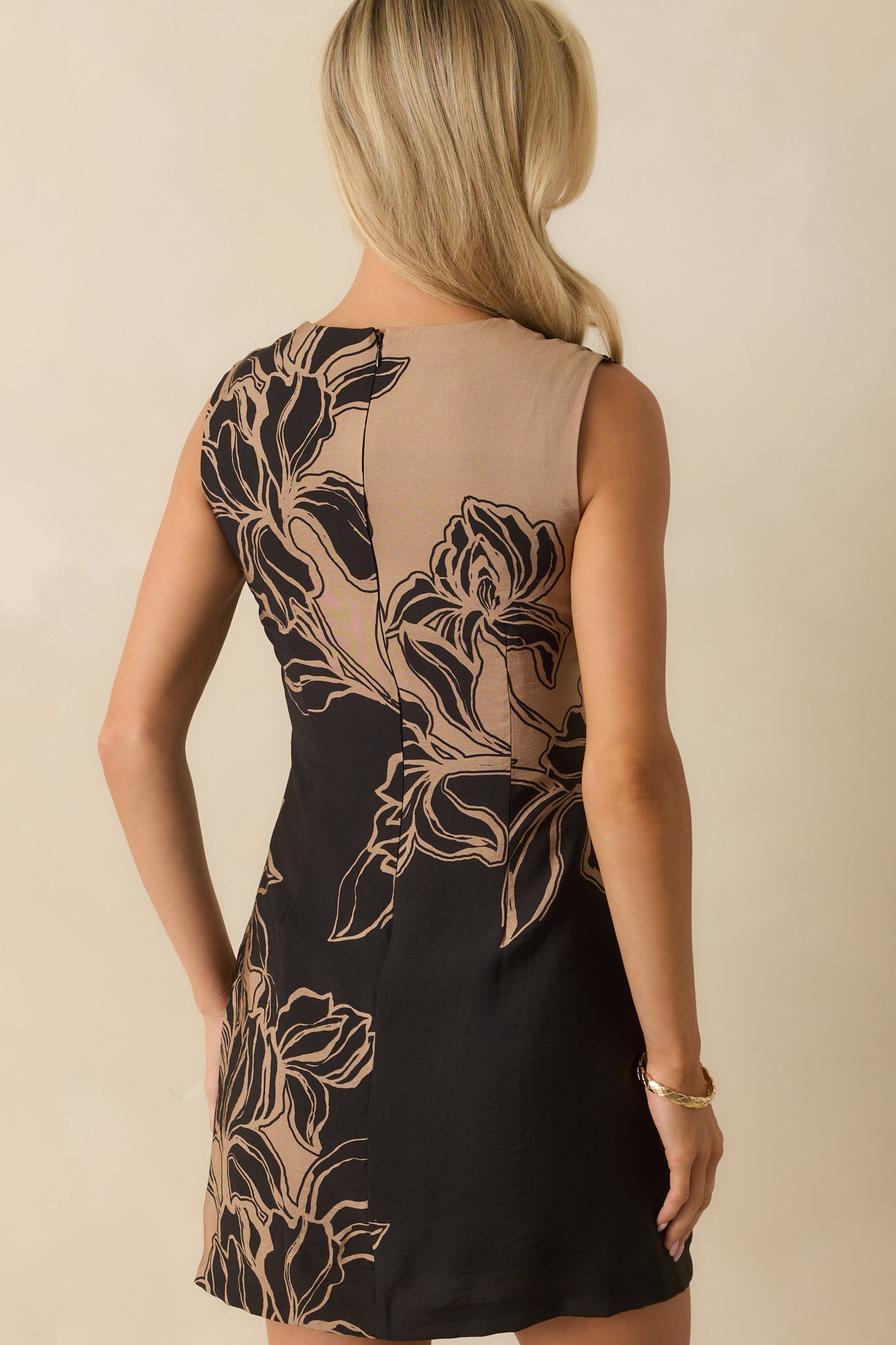 Rear view of the black mini dress with hidden zipper closure and sleek colorblock finish.