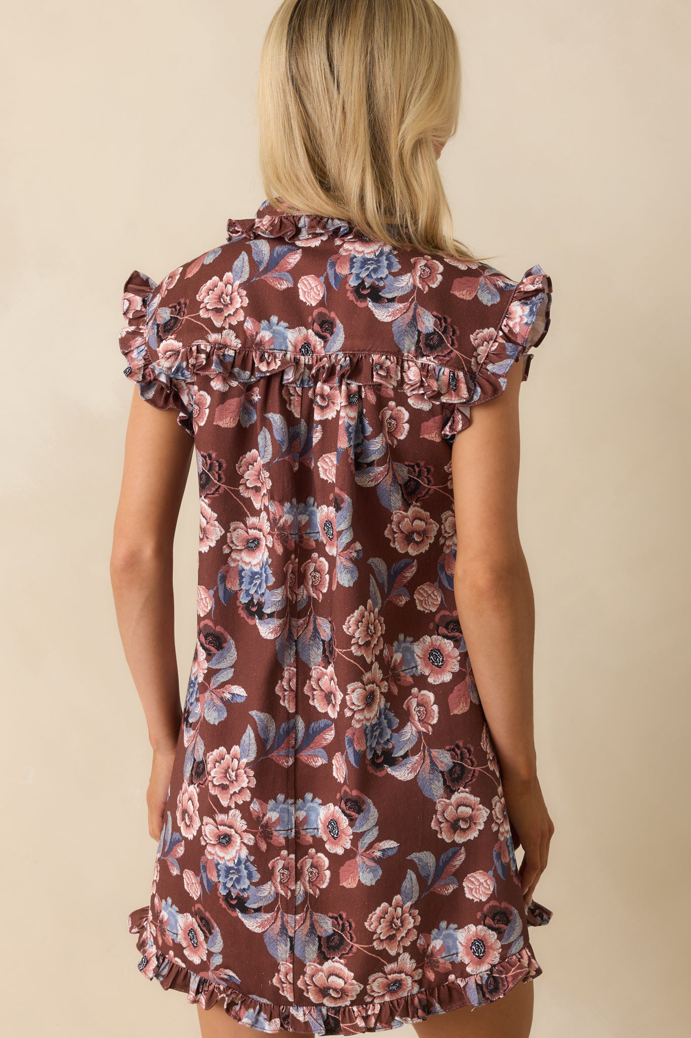 Rear view of the brown denim mini dress with paneled design and ruffle trim hemline.