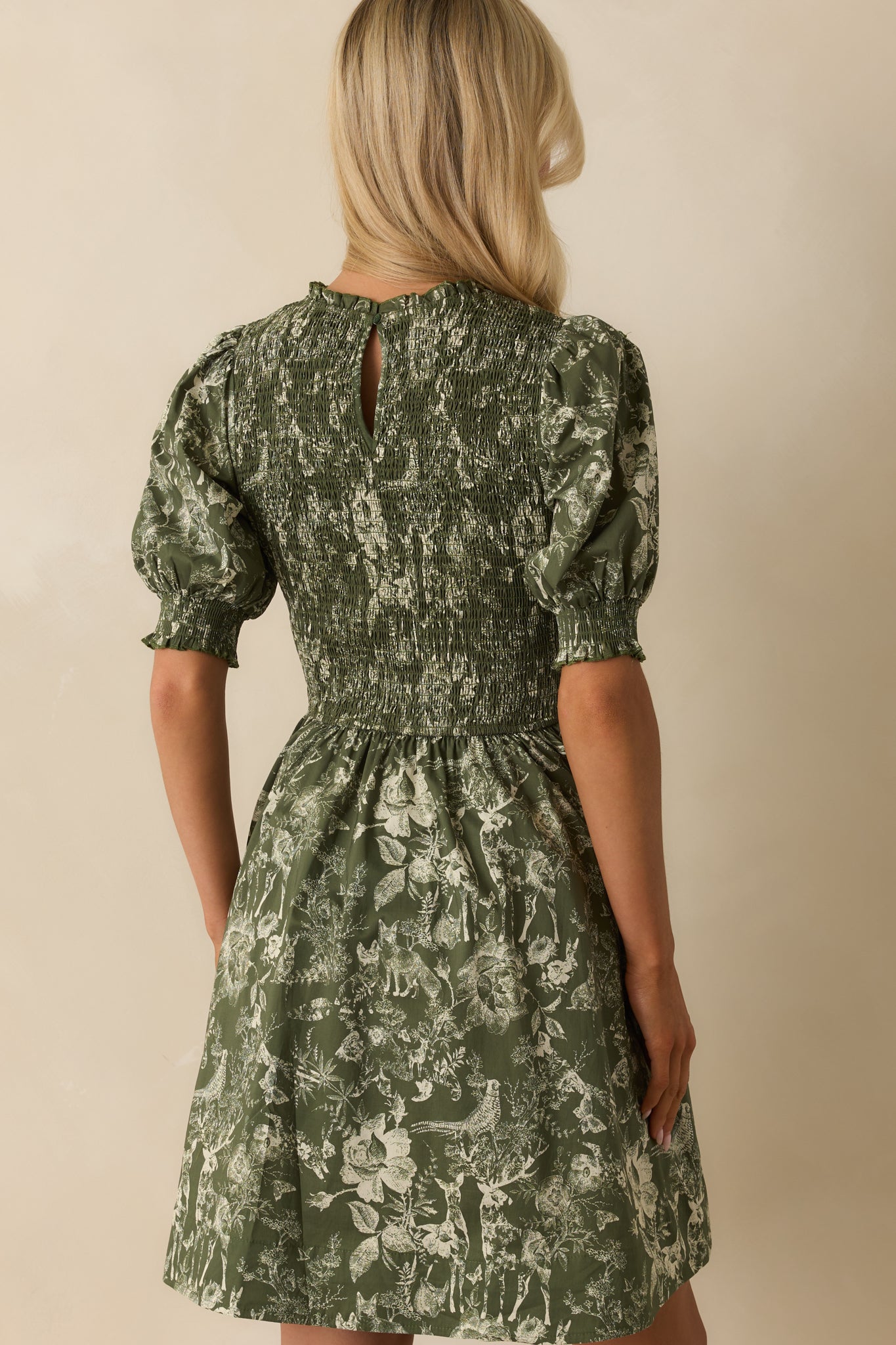 Rear view of green mini dress showing back keyhole button closure and fully smocked bodice.
