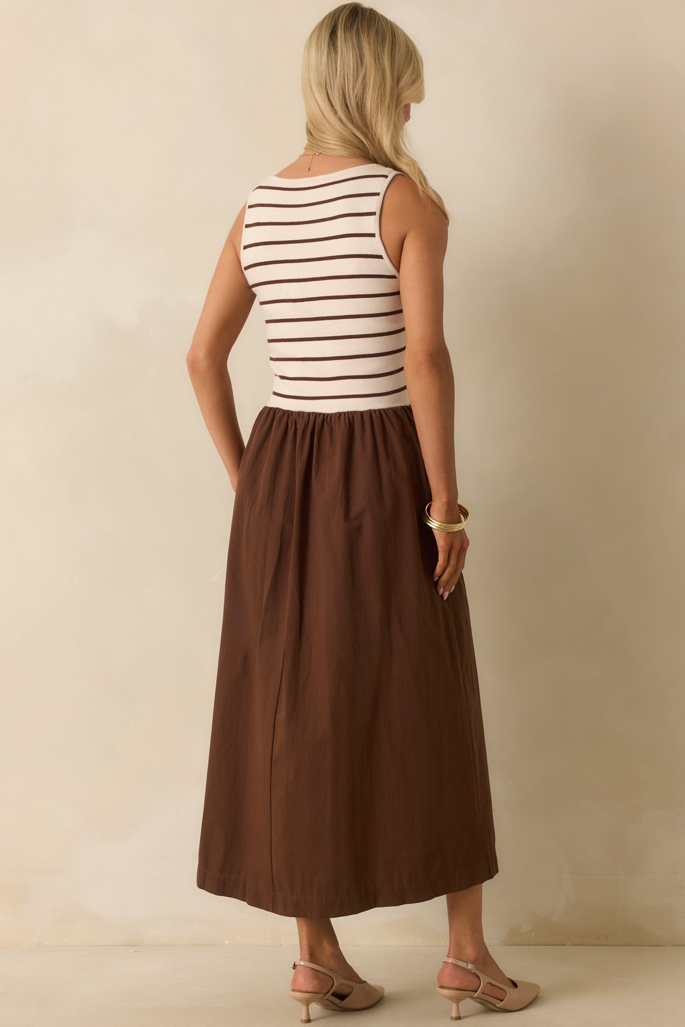 Rear view of the maxi dress with wide straps, a gathered waist seam, and solid brown skirt.