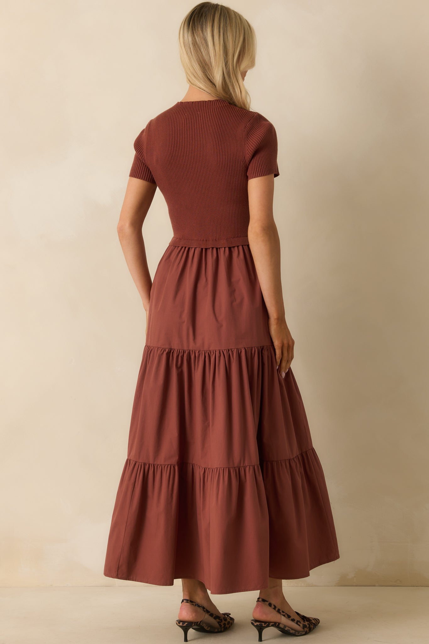Rear view of the rust maxi dress showing the ruffle waist seam and tiered skirt flow.