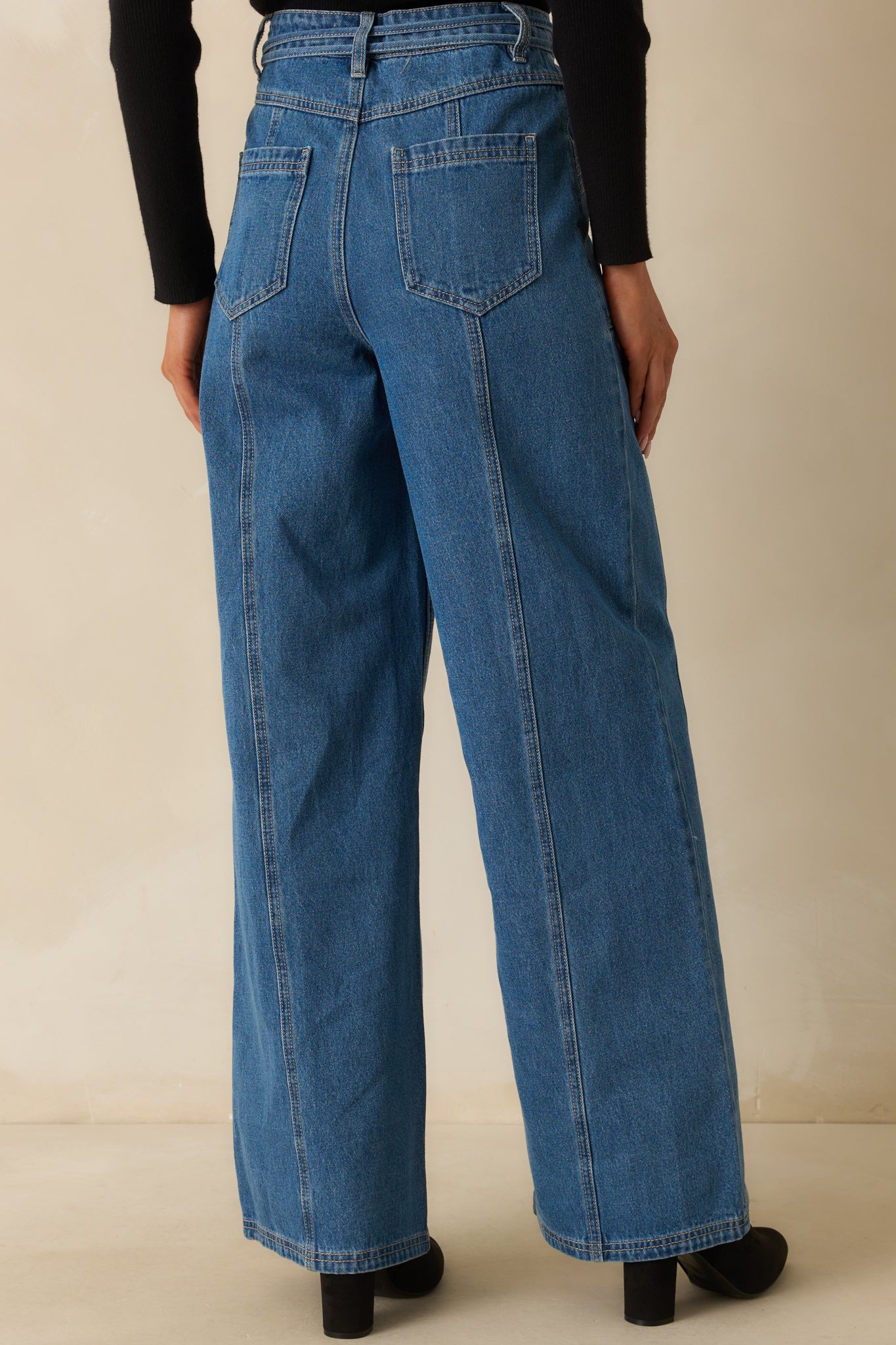 Rear view of the wide-leg jeans with paneled design and patch pockets.