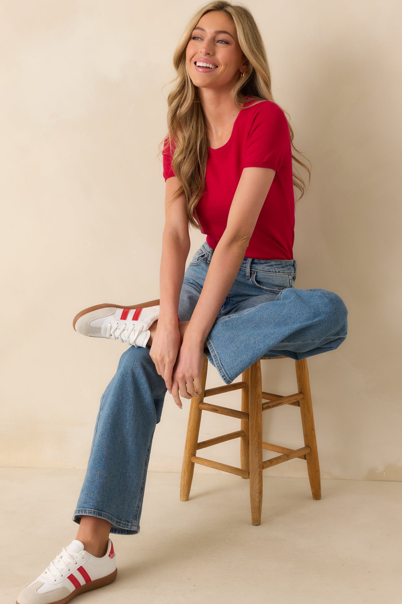 An angled full body view displaying the short sleeves and overall shape of the red top.