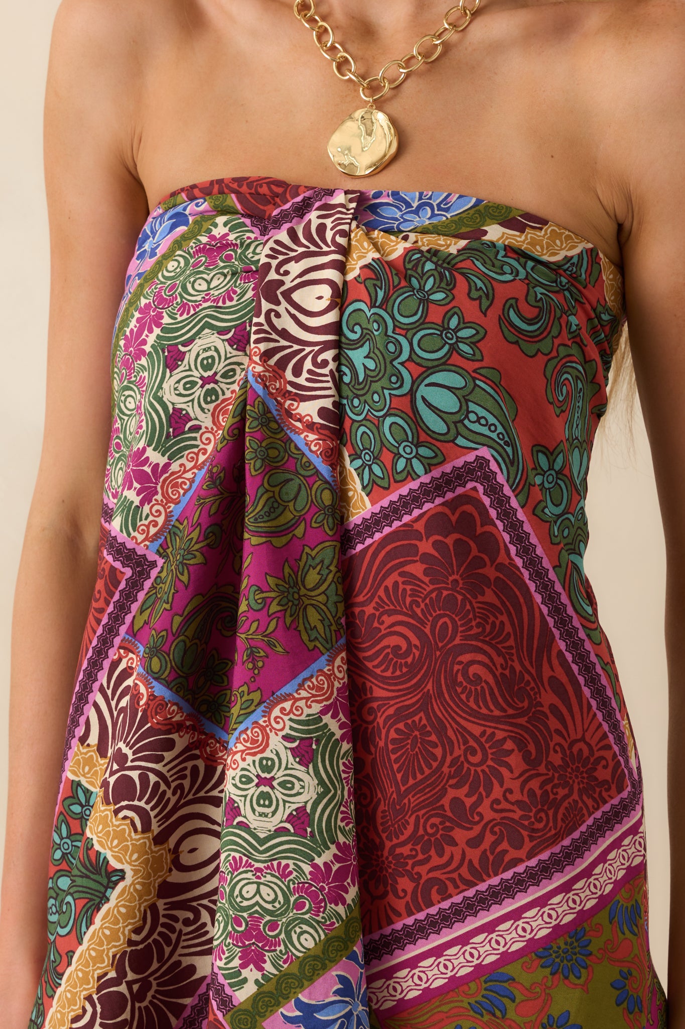 Close-up of the red patchwork print fabric and front box pleat detail on the midi dress.