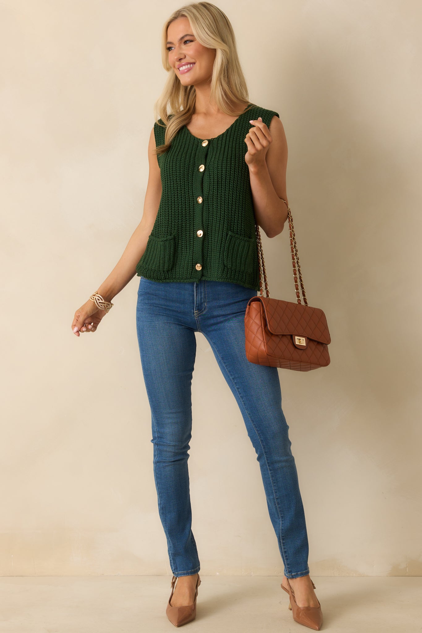 Ribbed knit hunter green vest styled with functional pockets and a relaxed sleeveless fit.