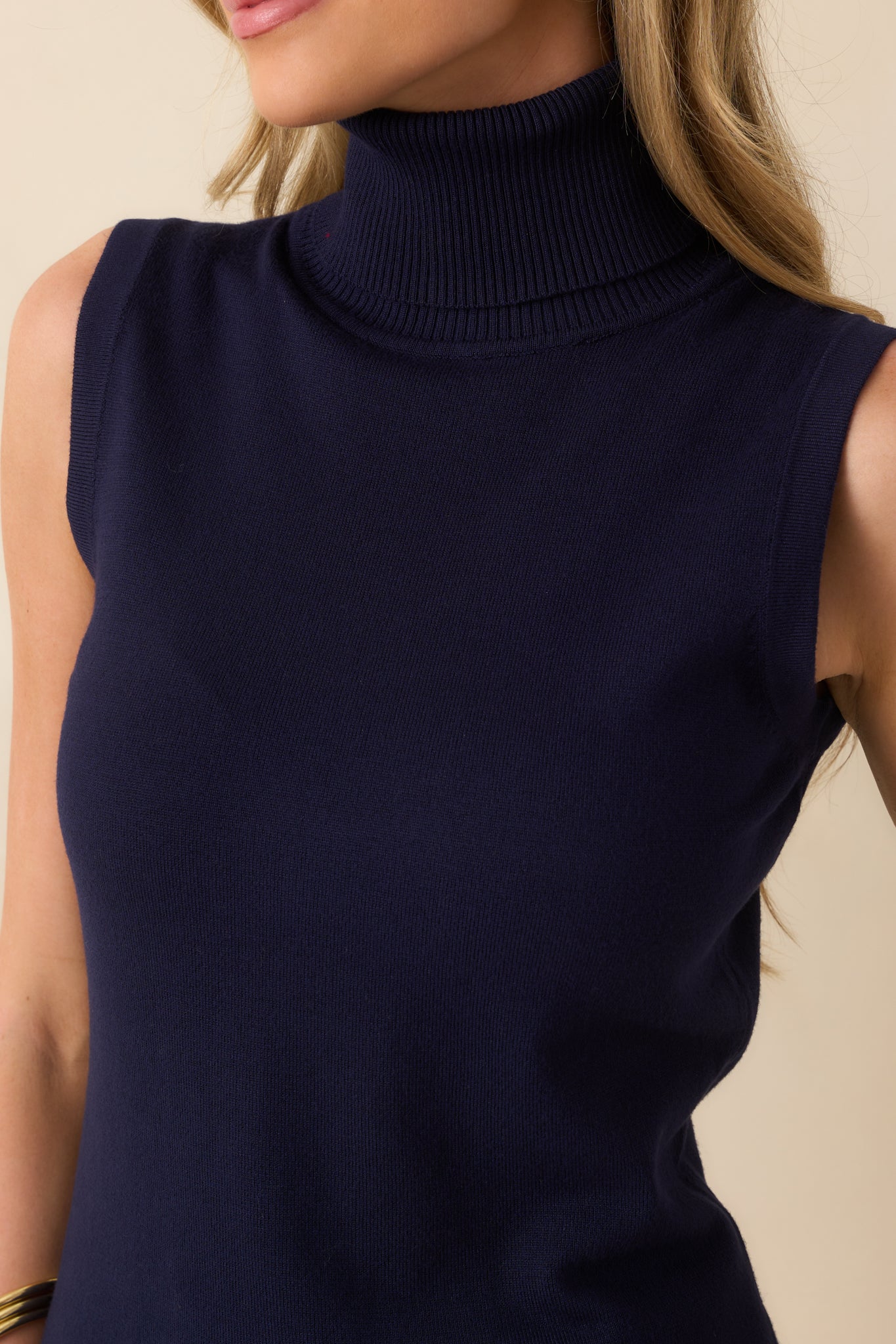 Zoomed-in view of the small ribbed texture and soft navy knit fabric near the collar and upper body.