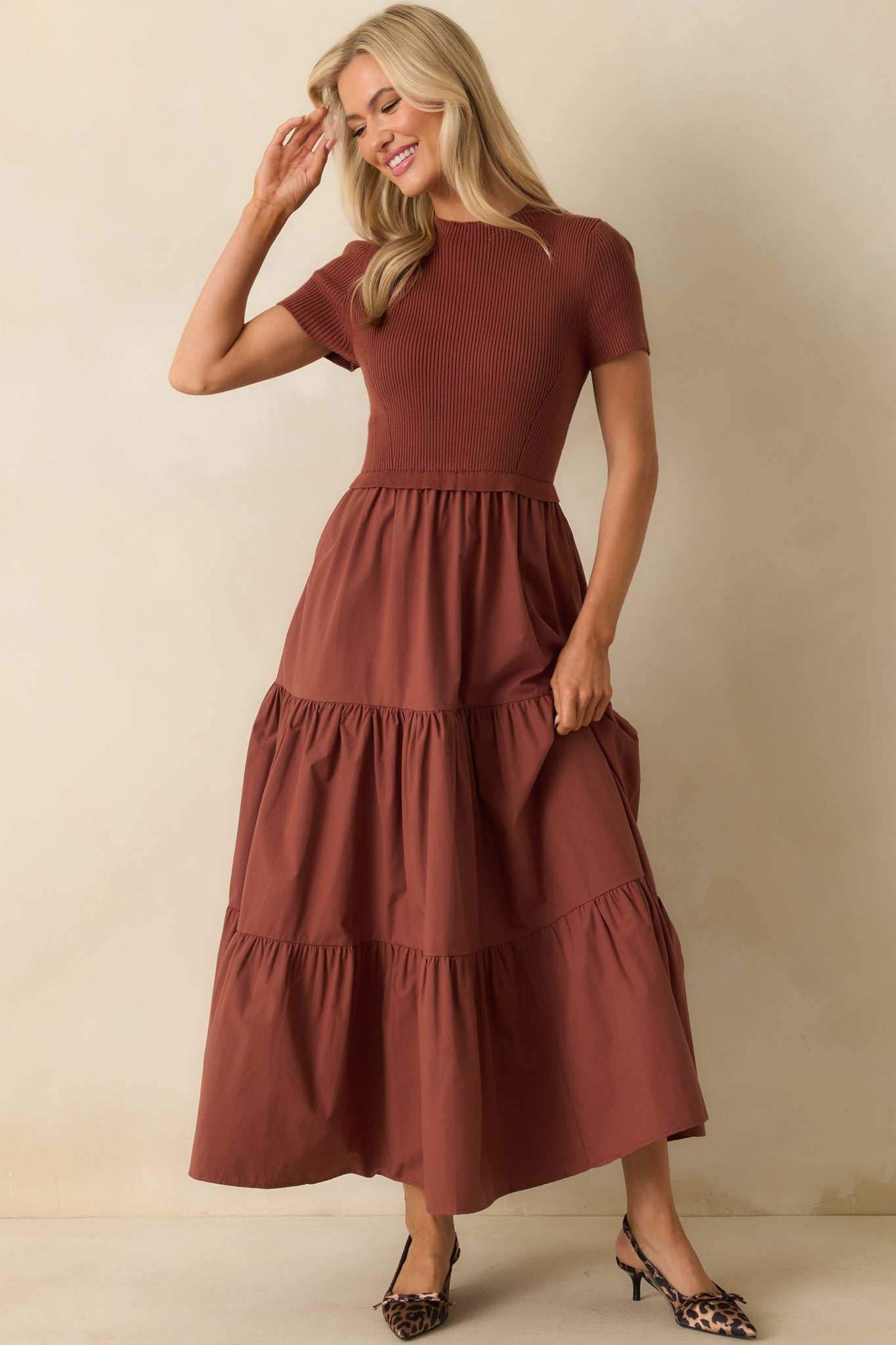 Dress combining a ribbed top with a fabric-contrasted tiered skirt in rust tones.