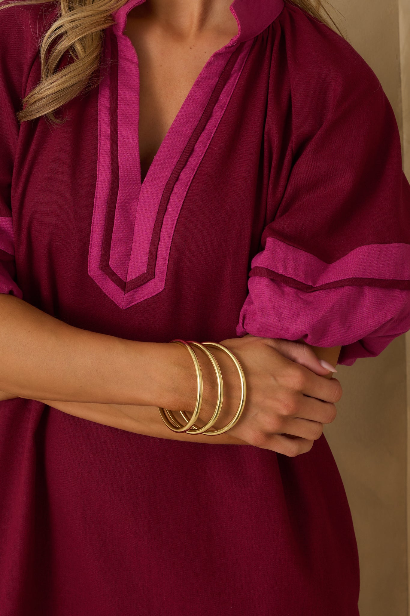 A close-up cropped shot of the rigid gold bangles highlighting their smooth, reflective finish.