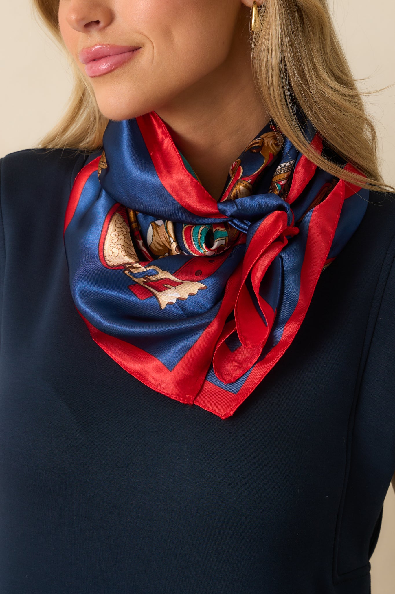 Satin scarf tied loosely at the neck, highlighting the playful mix of gold, green, and white details against the navy base.