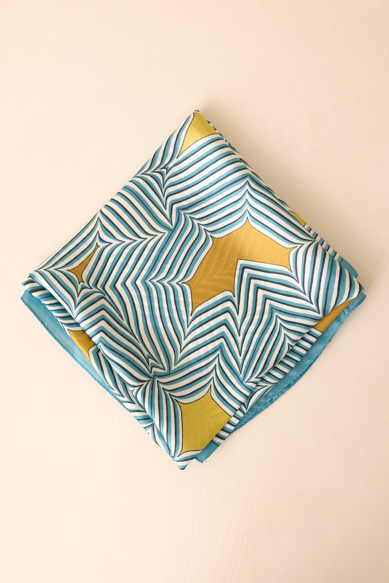 Scarf neatly folded into a square, showcasing the bold blue base with golden yellow accents and balanced stripe pattern.