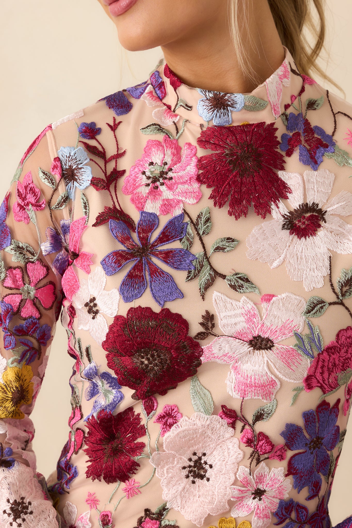 Detailed close-up of the sheer floral overlay fabric texture and subtle stitching