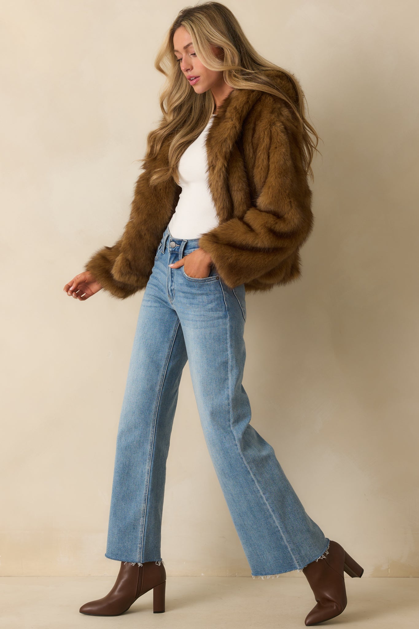 Side-angled view of the brown faux fur jacket showing its silhouette and hood.
