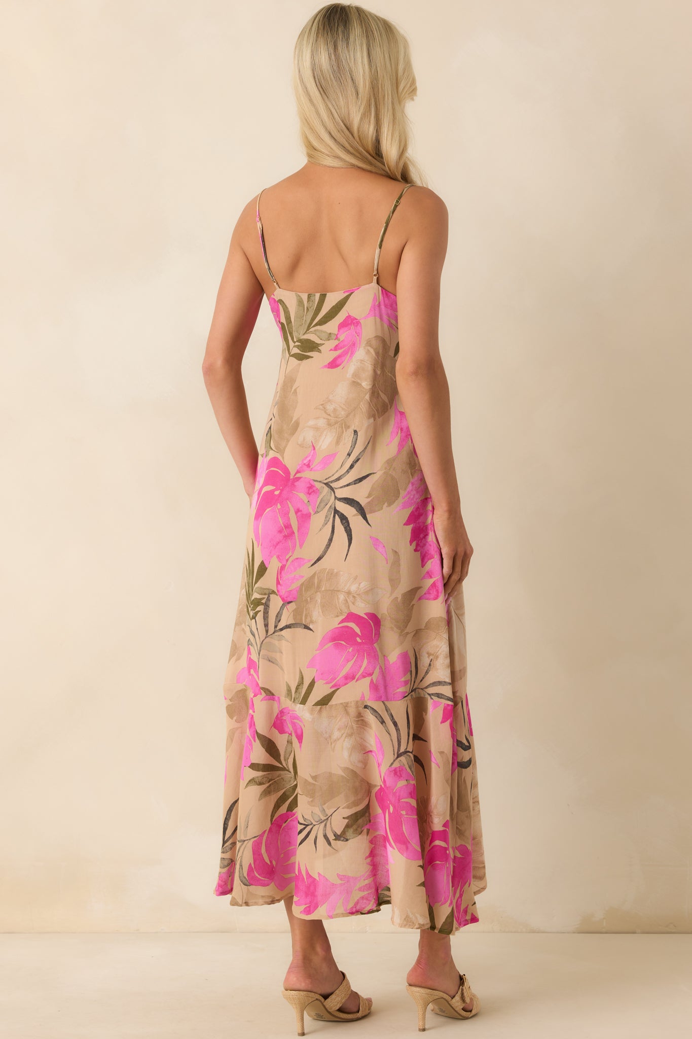 A view from behind of the tan maxi dress showing the adjustable spaghetti straps, smooth back fabric, and flowing skirt.