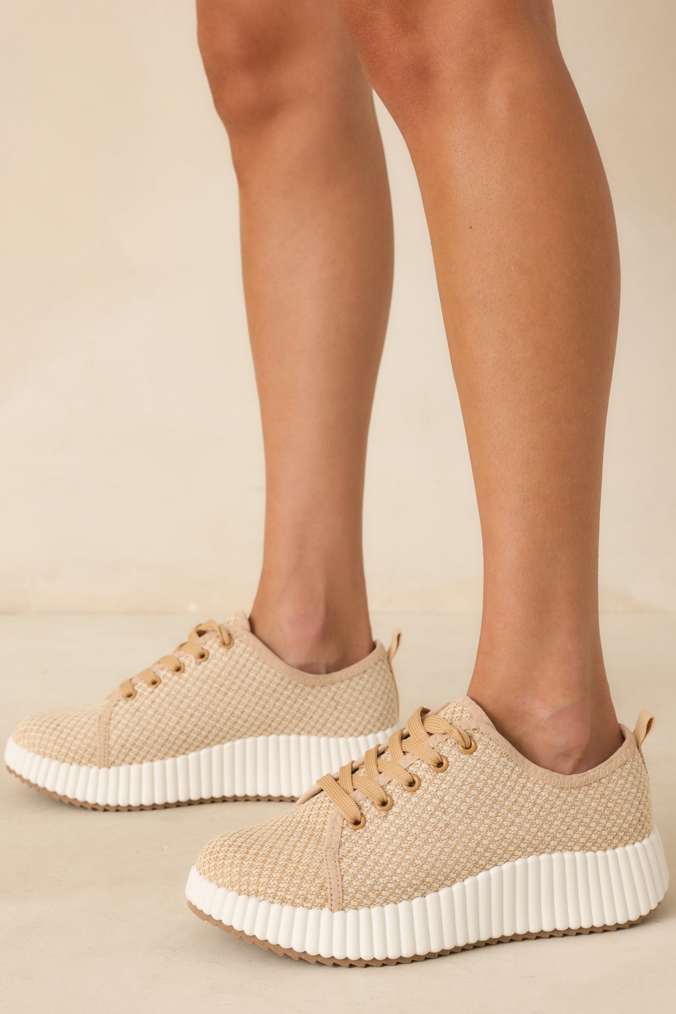 An angled shot emphasizing the contrast between the textured tan fabric and the smooth white platform sole.