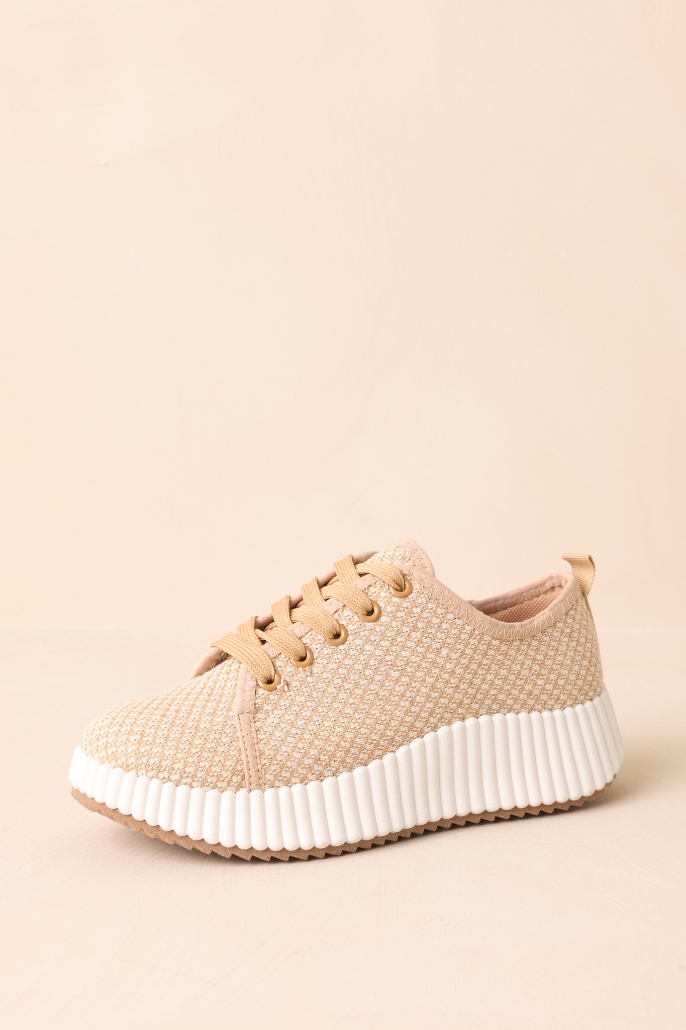 Tan woven sneakers with white rubber platform sole shown from a front angle.