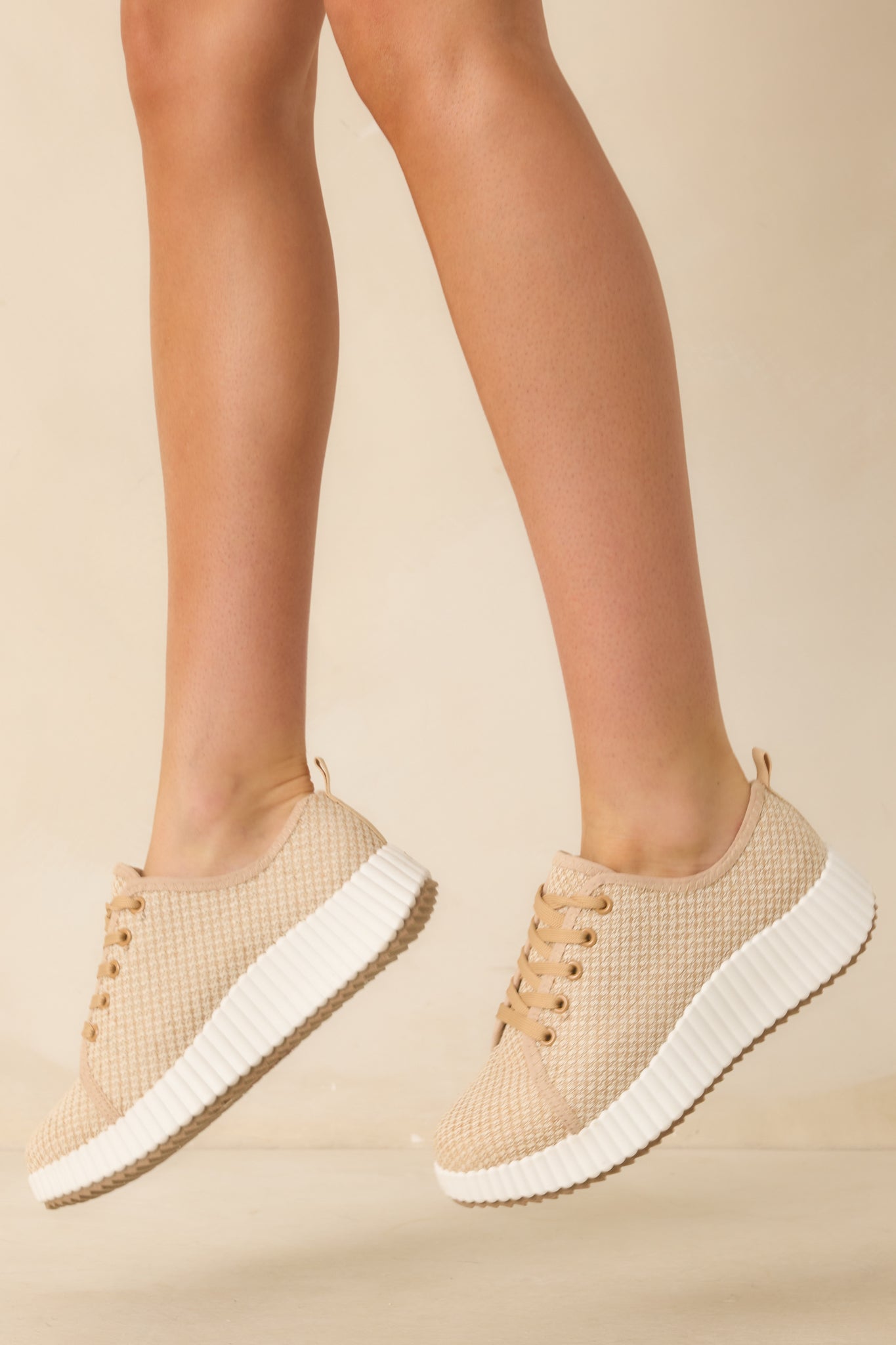 Tan woven sneakers with white rubber platform sole and matching laces.