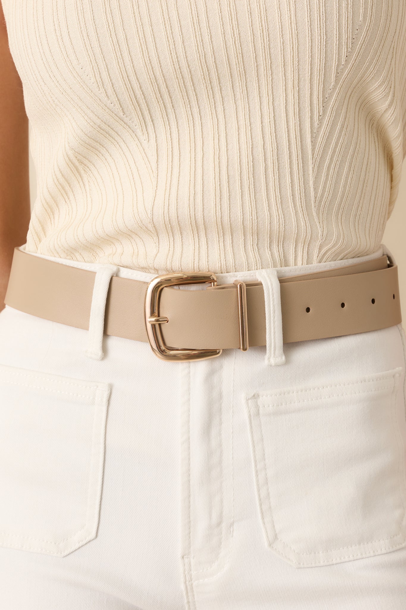 Cropped view of the taupe belt showing the gold-tone square buckle and stitched faux leather material.
