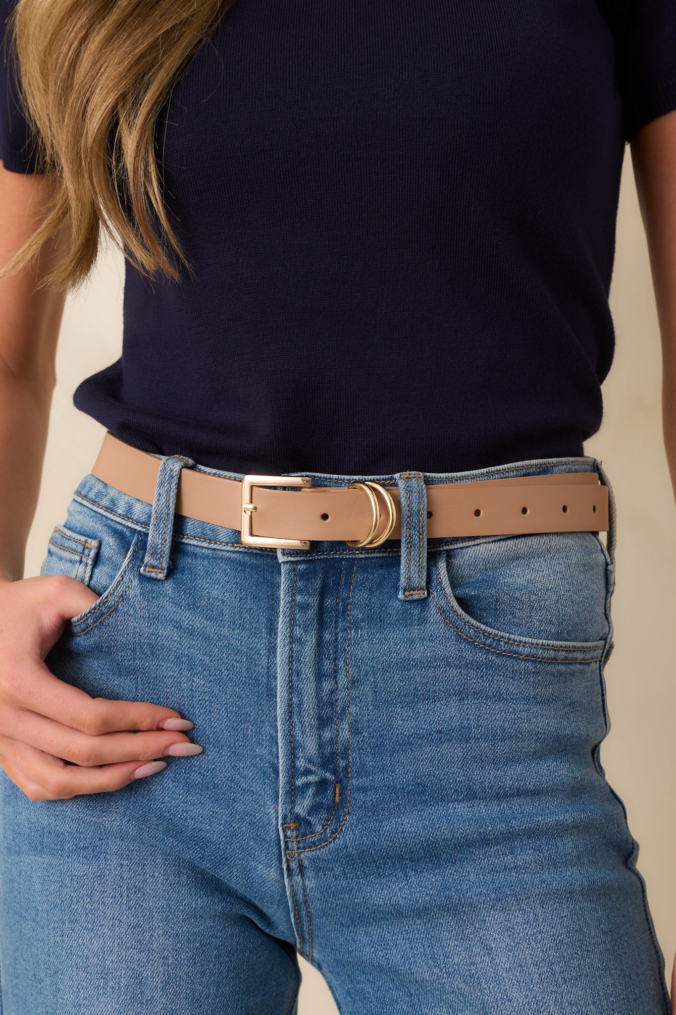 Cropped front view of the beige belt showing the slim silhouette and polished gold-tone square buckle.