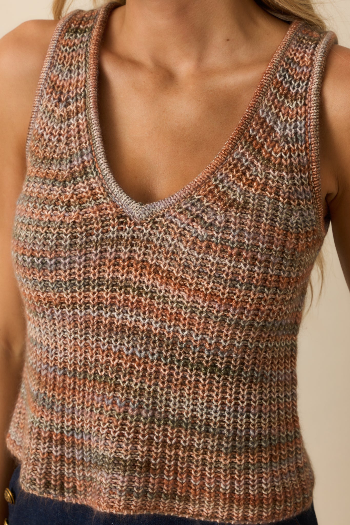 Detailed view of multicolor threads woven into the terracotta open-knit fabric.