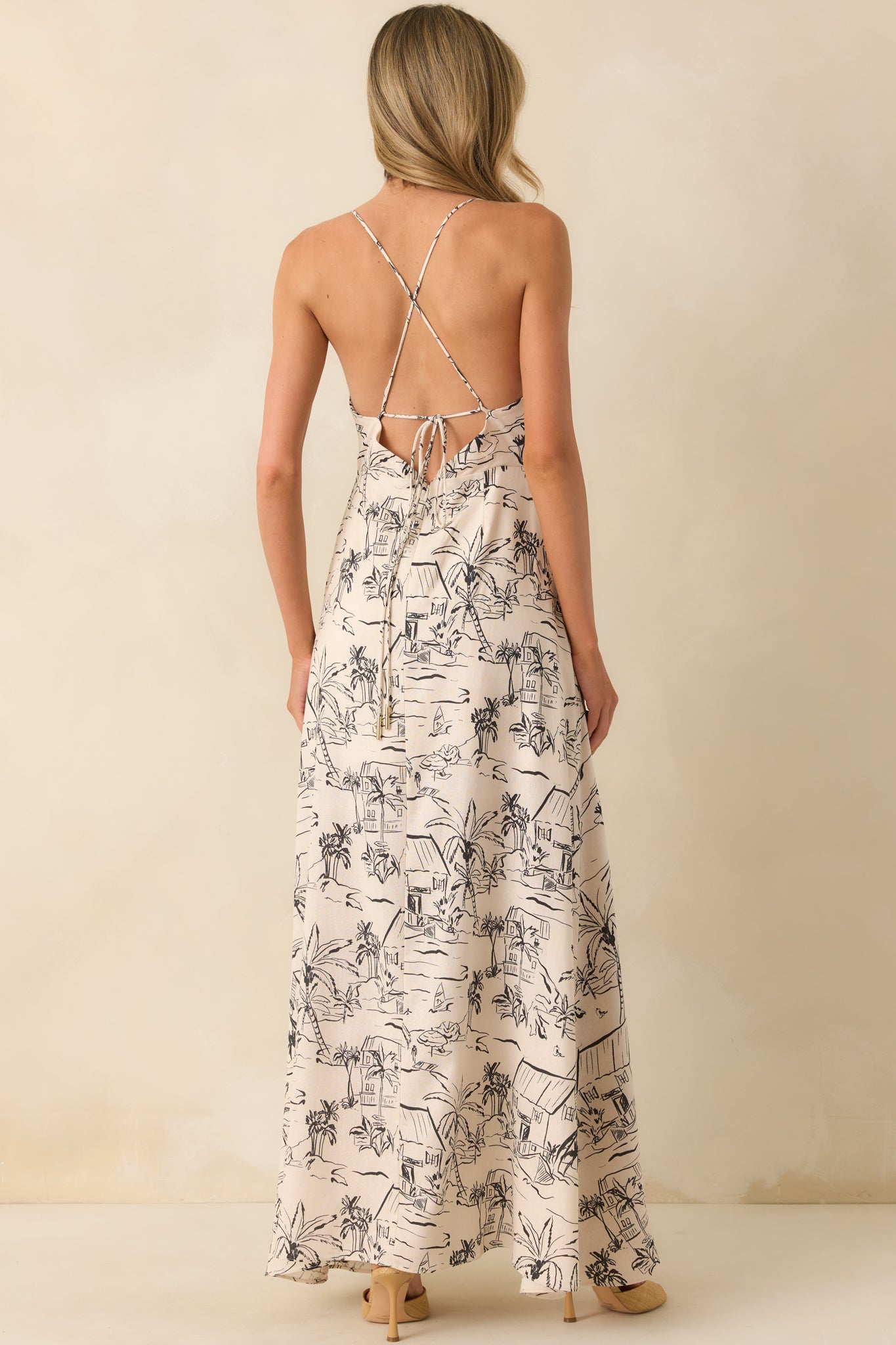 Rear view of the dress displaying the adjustable self-tie criss cross open back, hidden back zipper, and continued tropical print.
