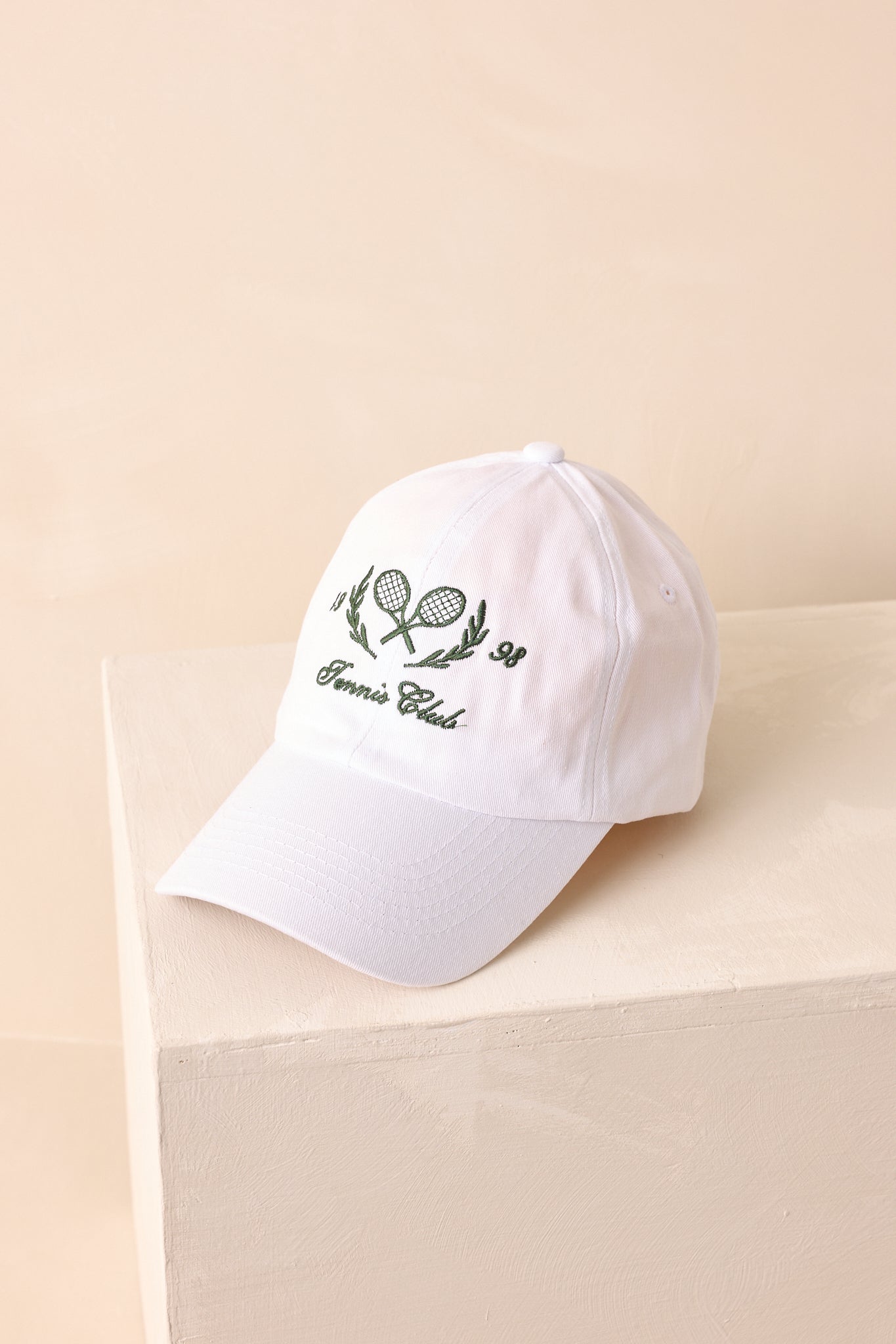 An overhead view of the white baseball cap highlighting a curved brim and panel stitching.