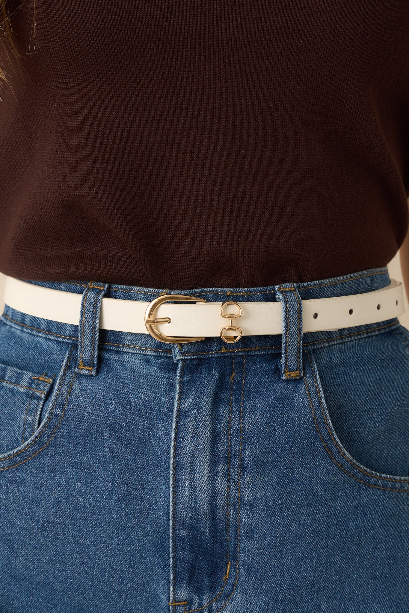 Zoomed-in image showing the texture of the faux leather, the gleaming gold-tone buckle, and the double ring accents.