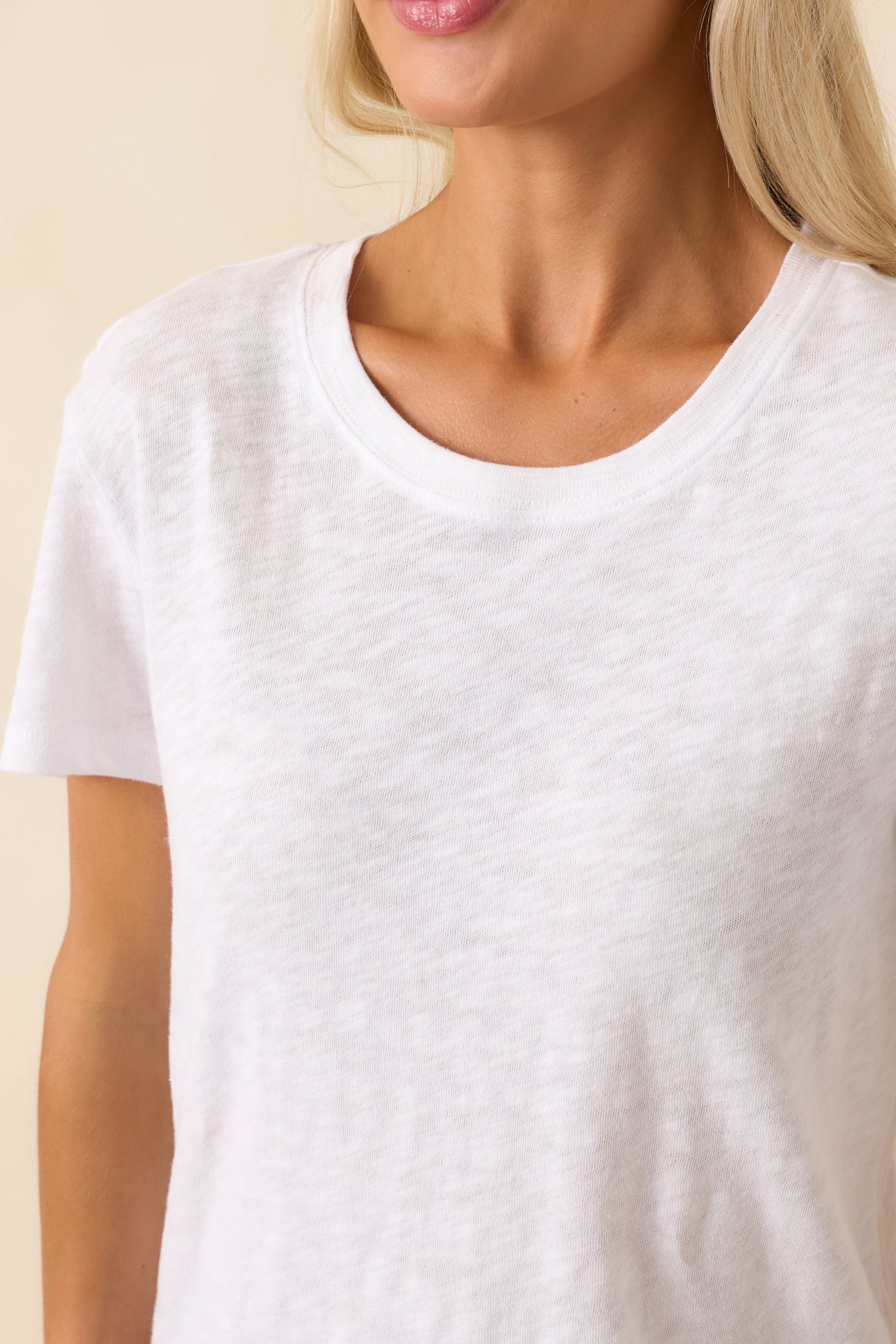 Close-up of the brushed slub jersey fabric texture and crew neckline stitching, emphasizing softness and quality.