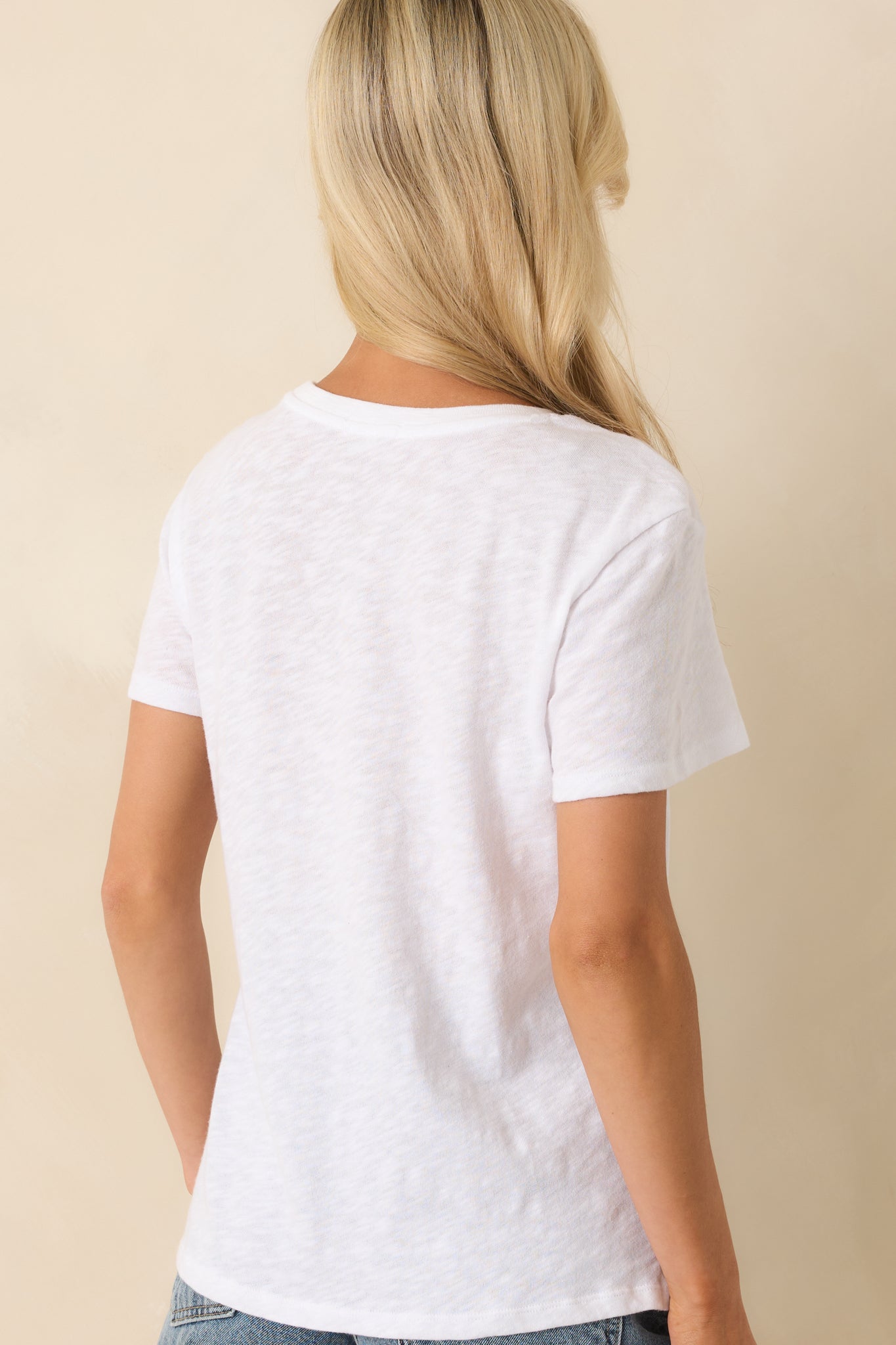 A view from behind of the white tee showing the regular fit, short sleeves, and clean back design.