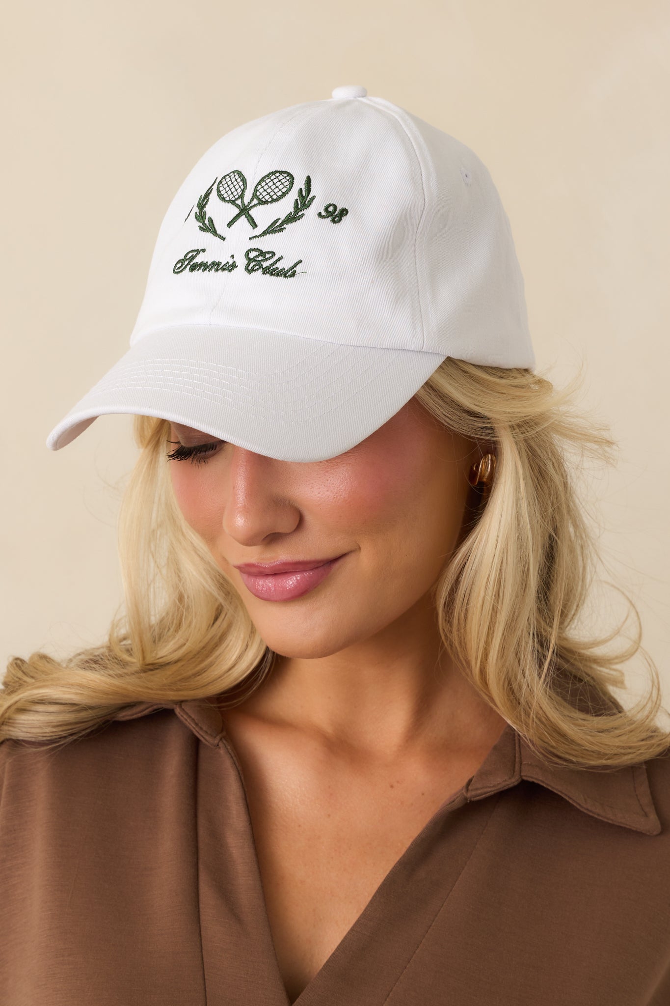 An angled front view of the white baseball cap showcasing embroidery and a structured six-panel design.