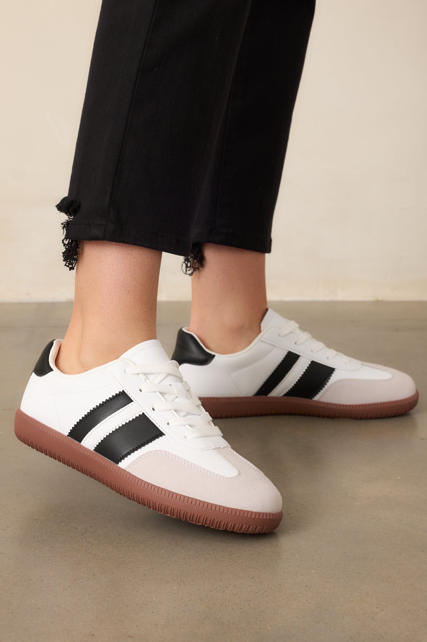 An angled front view of both sneakers, showcasing the round toe, white laces, and rubber sole.