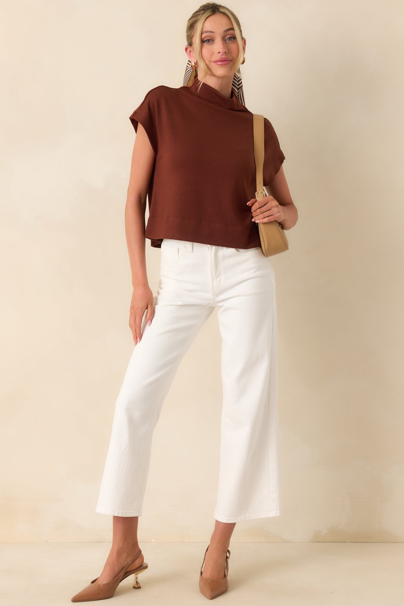 A pair of white jeans with a high-waisted silhouette, detailed with belt loops, front and back pockets, and a sleek cropped length that pairs well with any outfit.