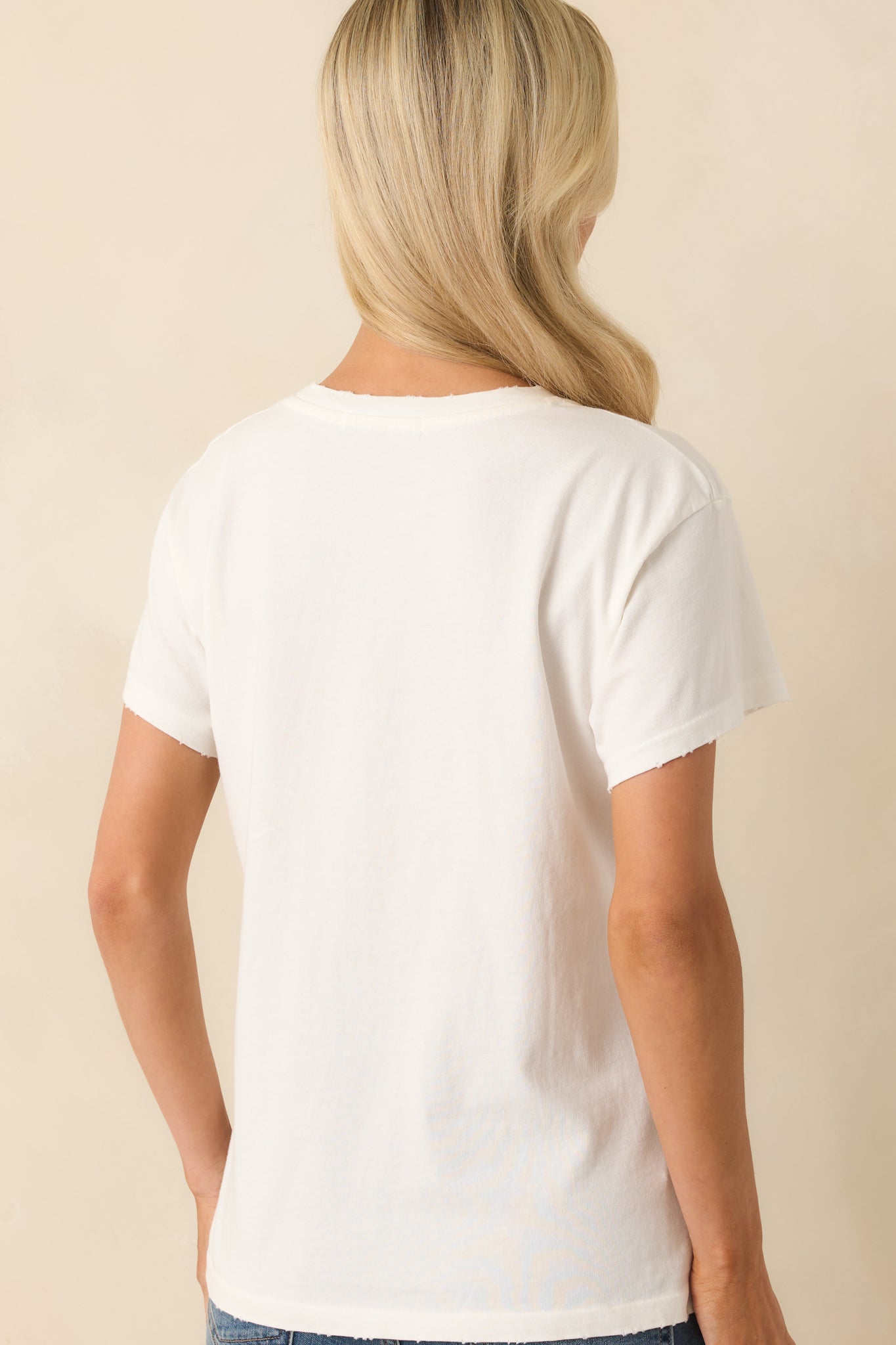 Back view of the white tee showing a plain design with short sleeves and a relaxed fit.