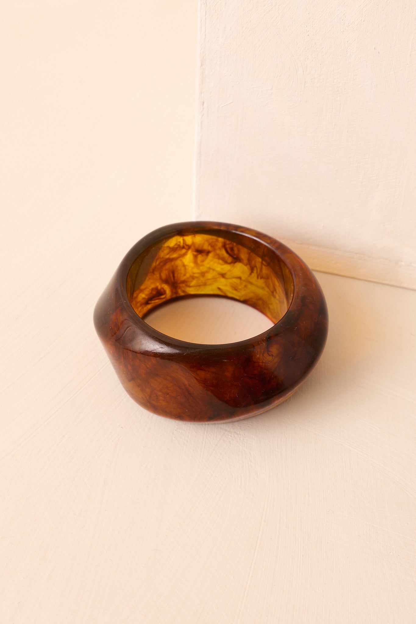 A close-up detail of the marbled acrylic texture and smooth curved edges of the bracelet.