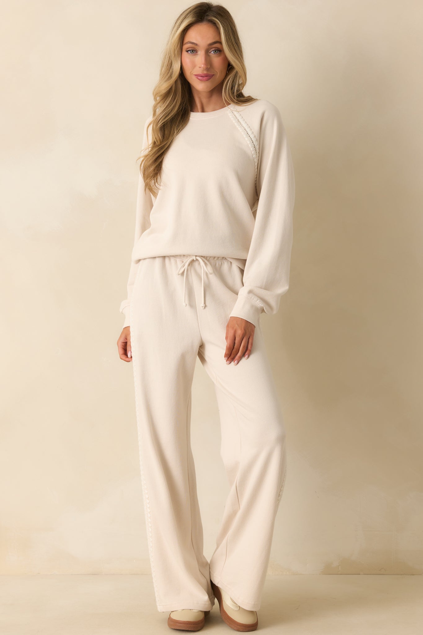 Wide leg ivory pants styled with a drawstring self-tie and flowy fit.